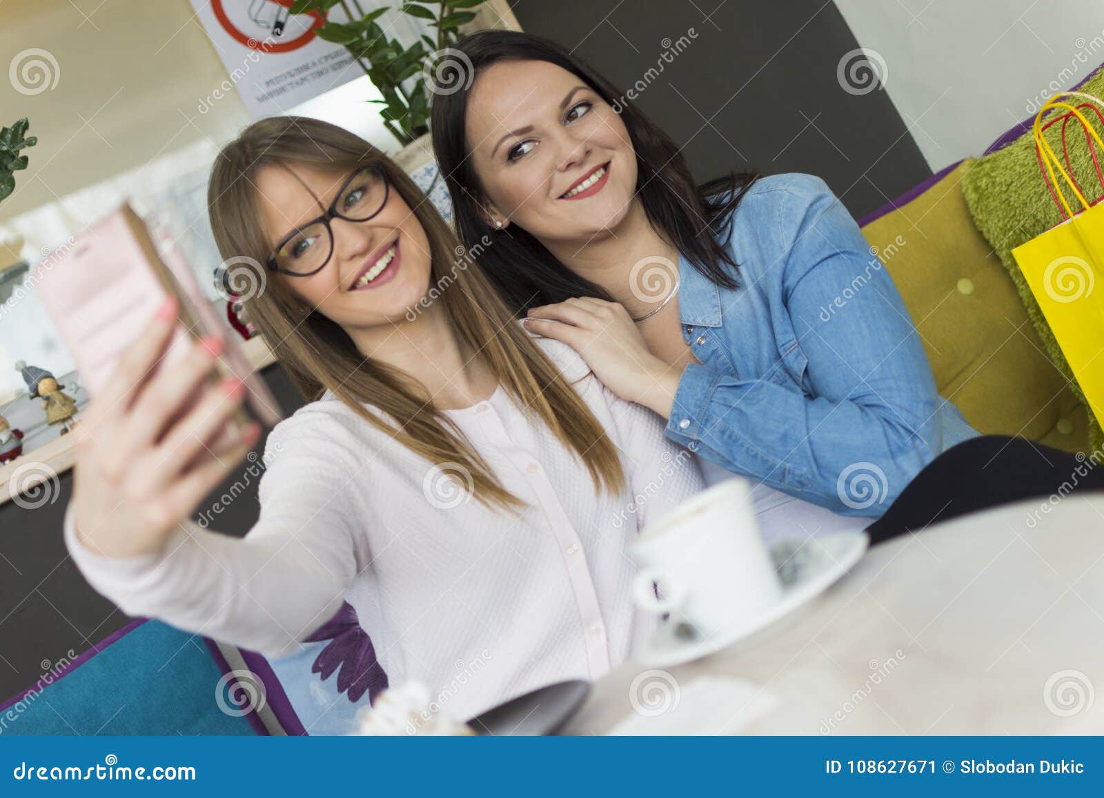 Two Adult Smiling Girls Photograph with a Mobile Phone Stock Image ...