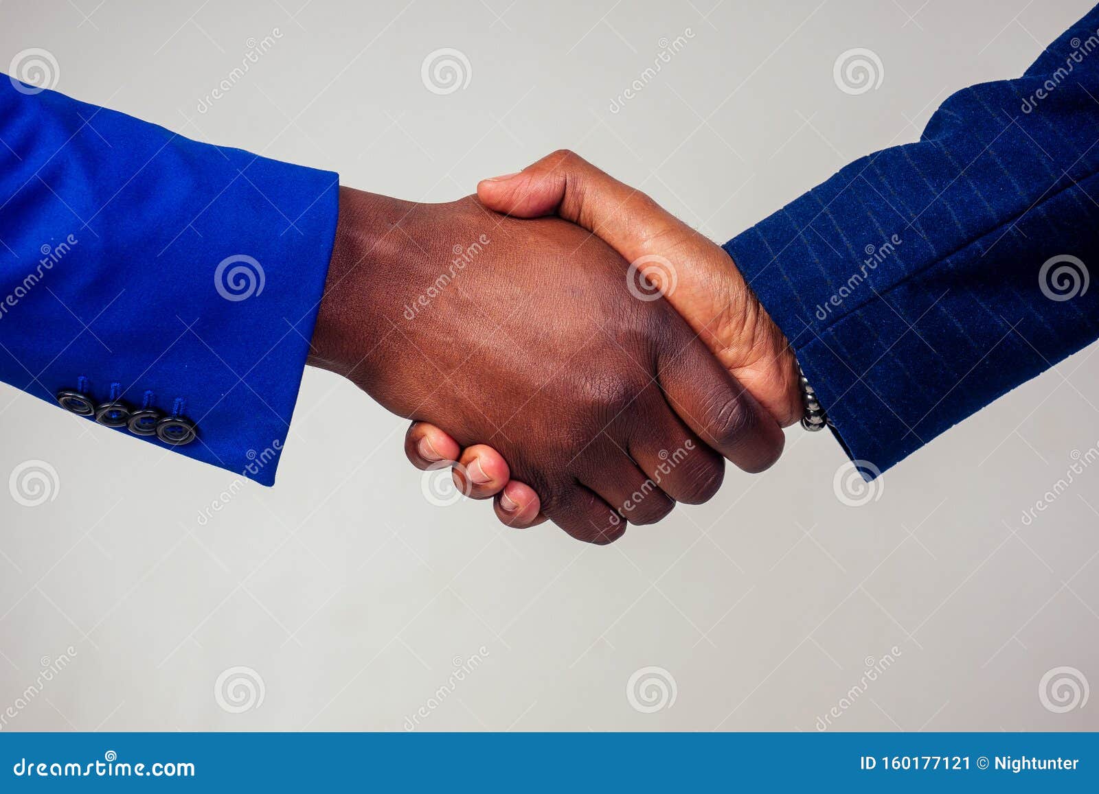 portrait of two businessmen shaking hands in a business meeting on white background in studio shot