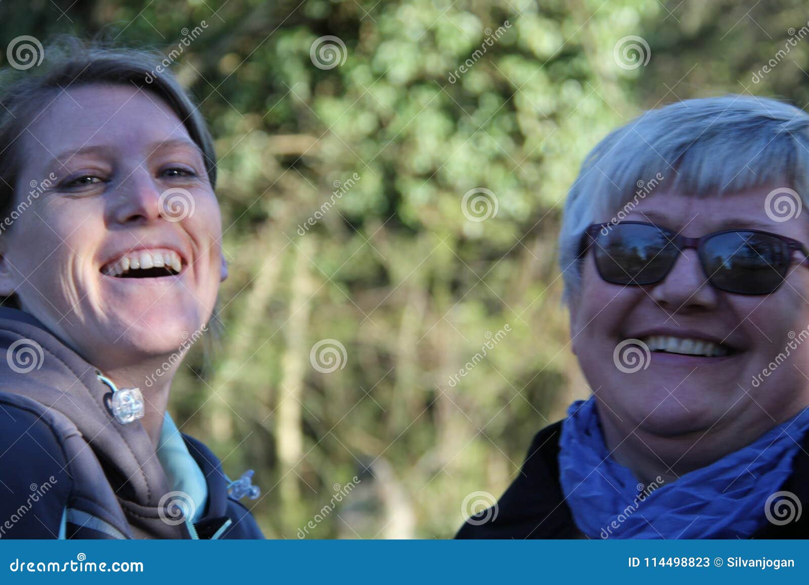 a portrait of two collegue ladies in the nature laughing