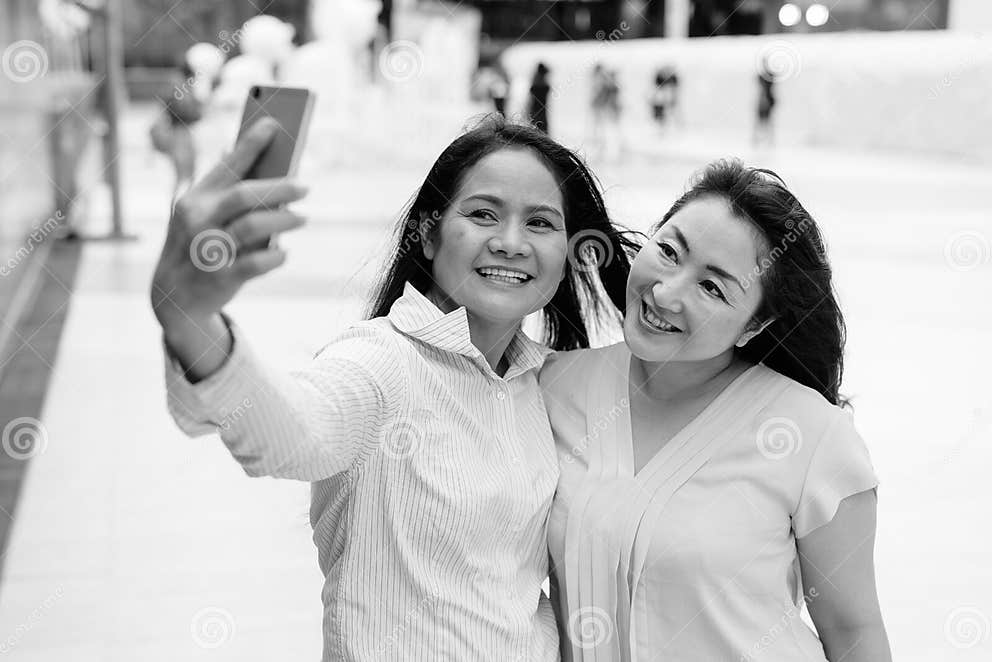 Two Mature Asian Women Together Taking Selfie With Mobile Phone Stock Image Image Of Asian
