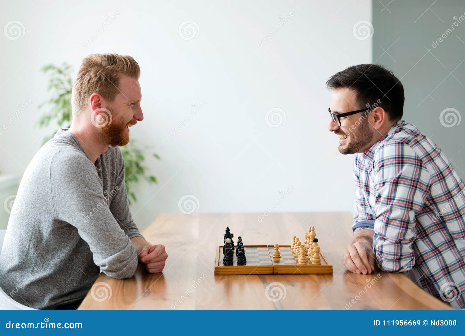 Premium Photo  Two young man are playing chess