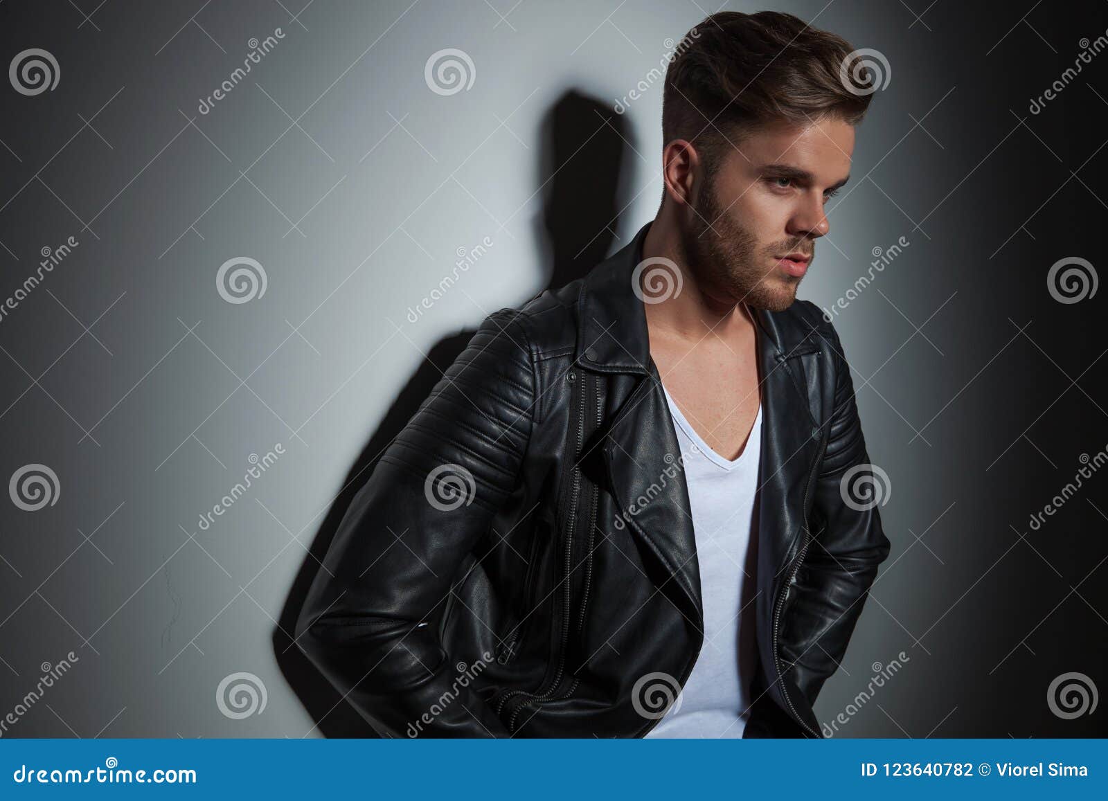 Portrait of Unshaved Man in Leather Jacket Leaning on Wall Stock Photo ...