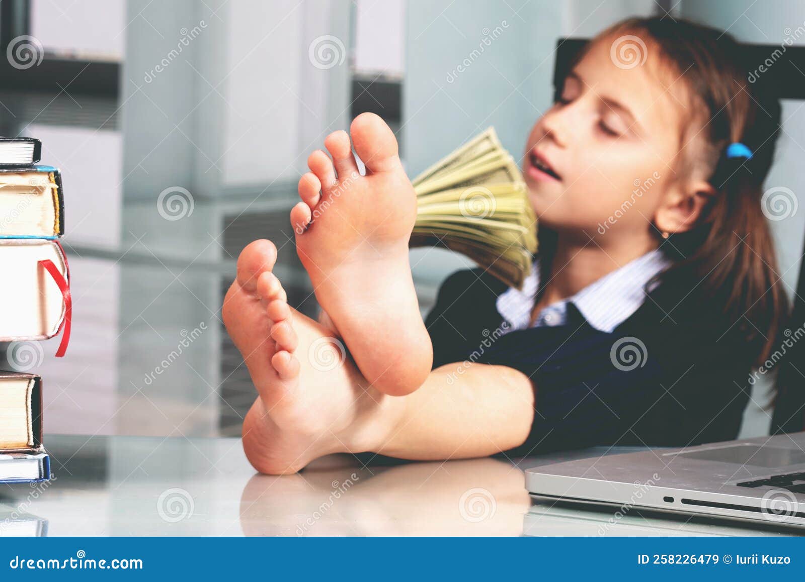portrait of very happy cute young business girl counts money profit. selective focus on bare feet