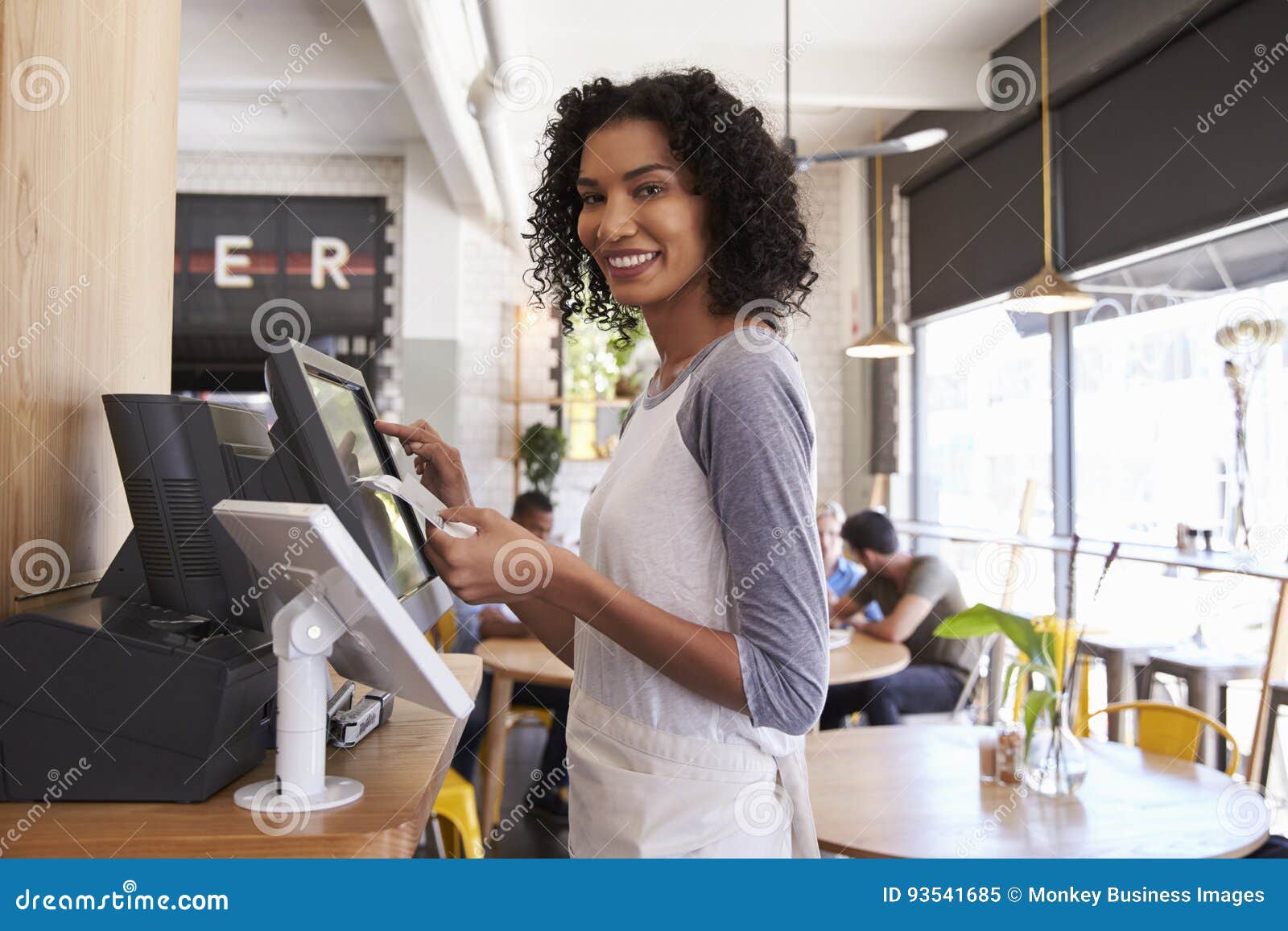 portrait of waitress at cash register in coffee shop