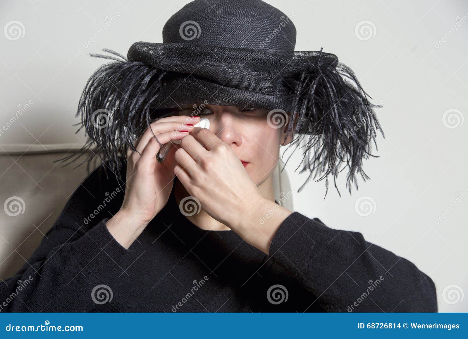 Portrait of a woman with black dress and hat looking sad. Portrait of sad woman in black with black hat