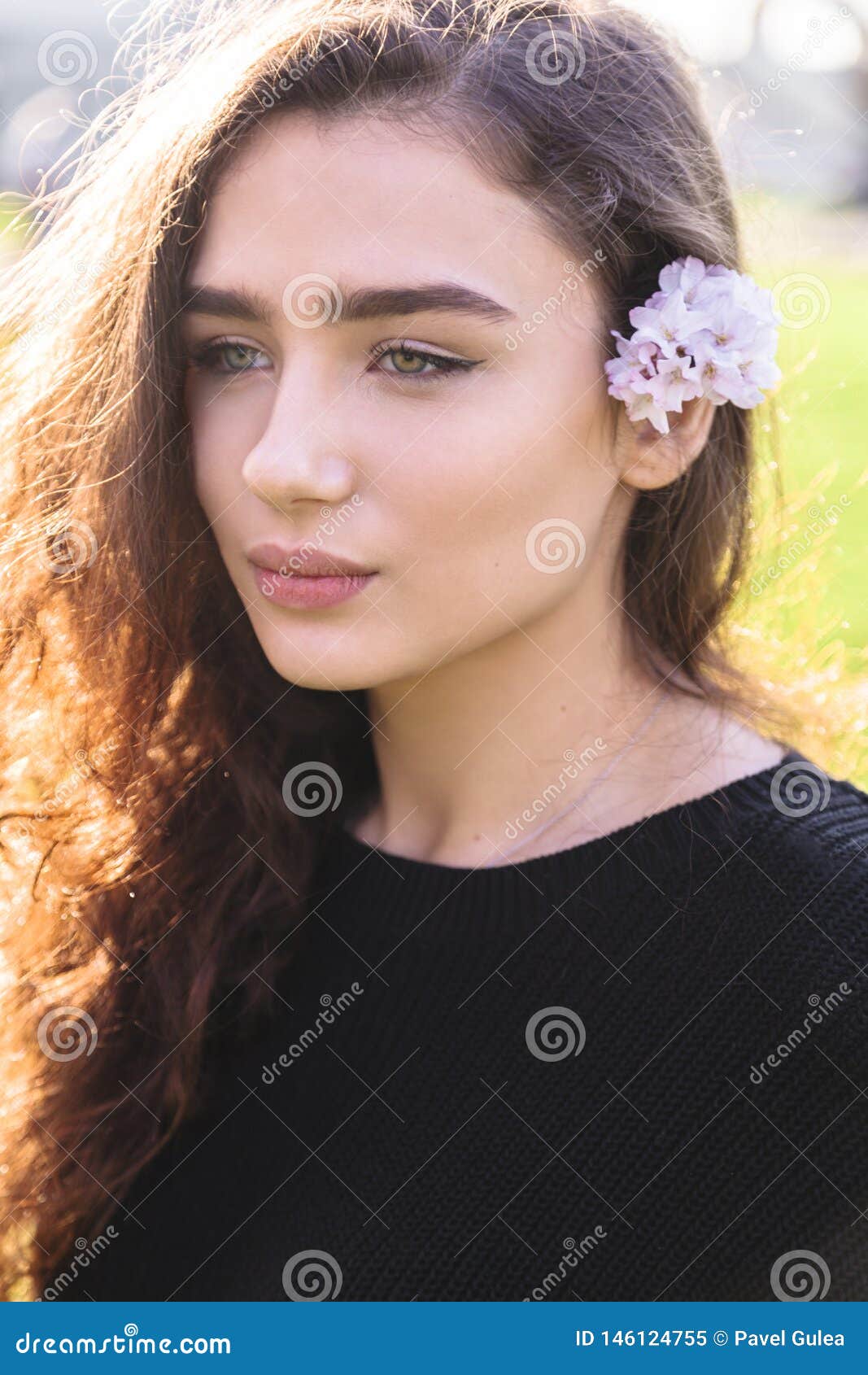 portrait of woman with pink flower behind her ear