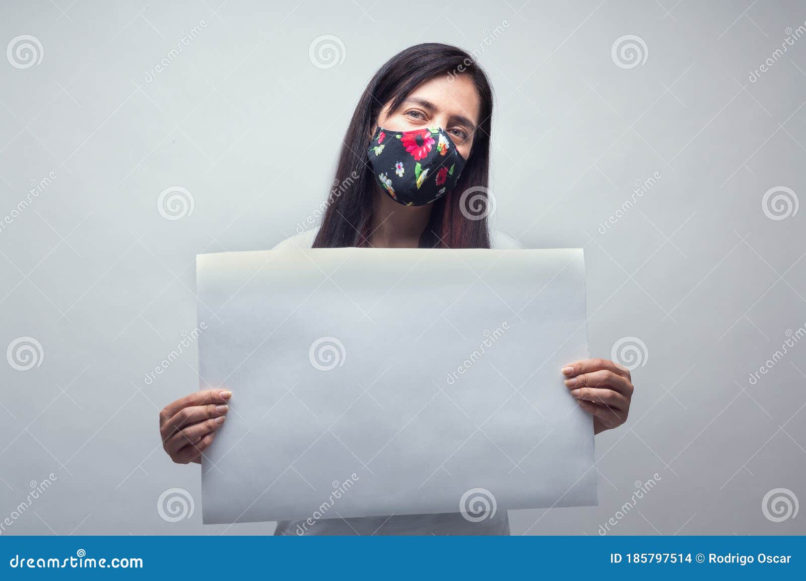 portrait of woman with white sign and face mask