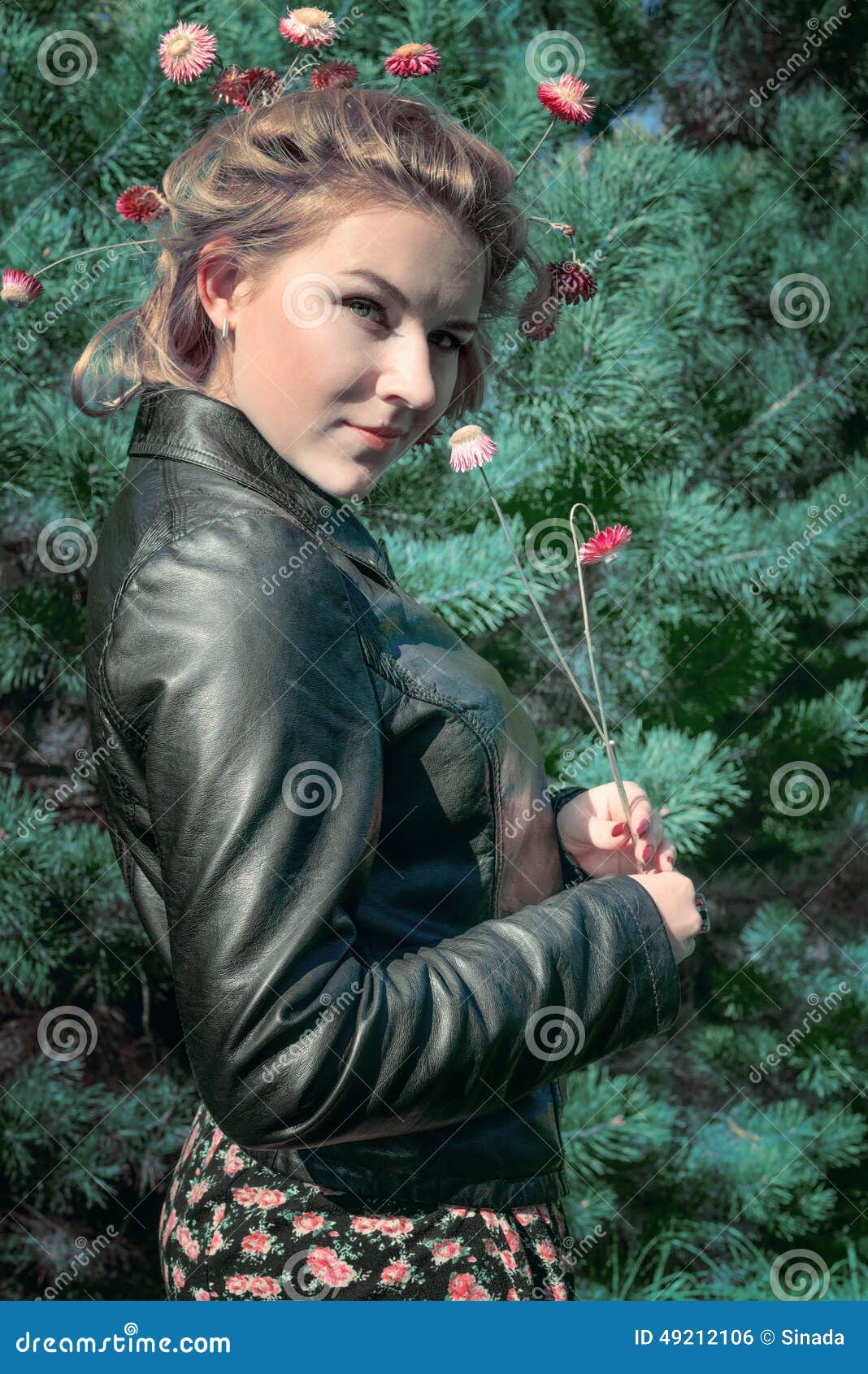 Portrait of wonderful young girl in fir-tree wood with flowers