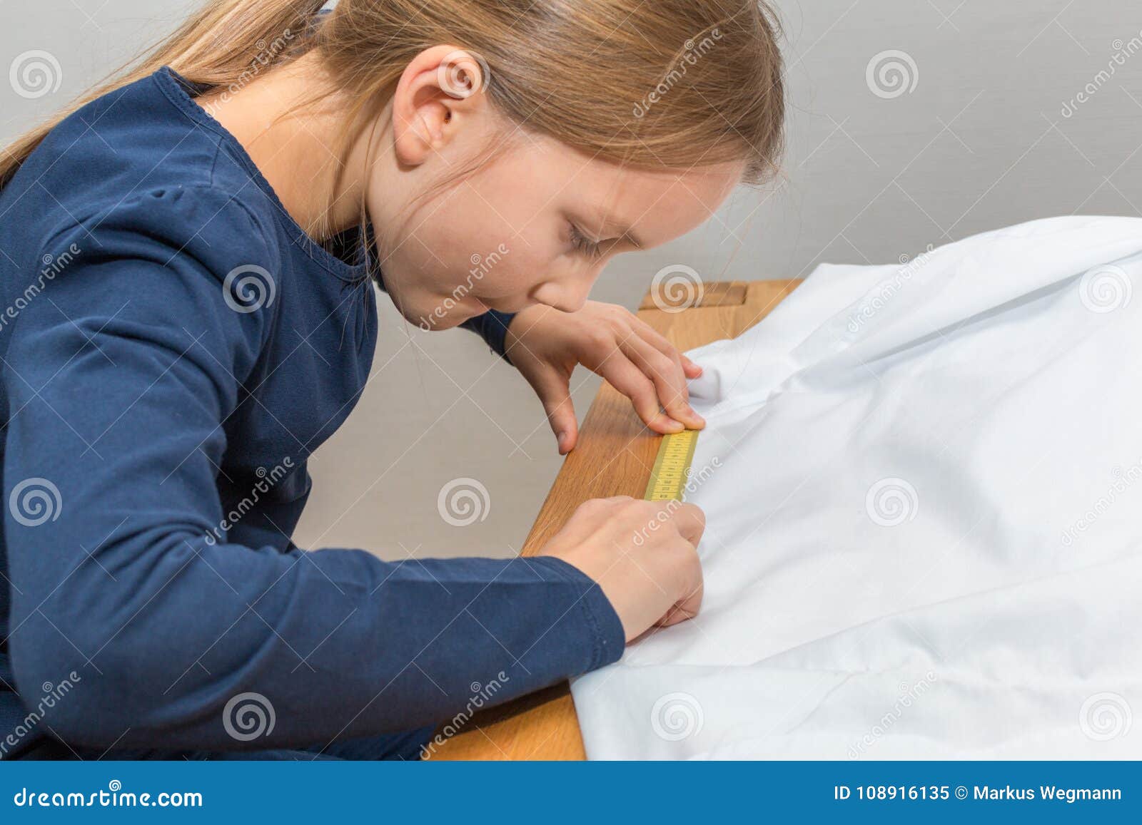 girl is measuring a white textil with a yellow measuring tape