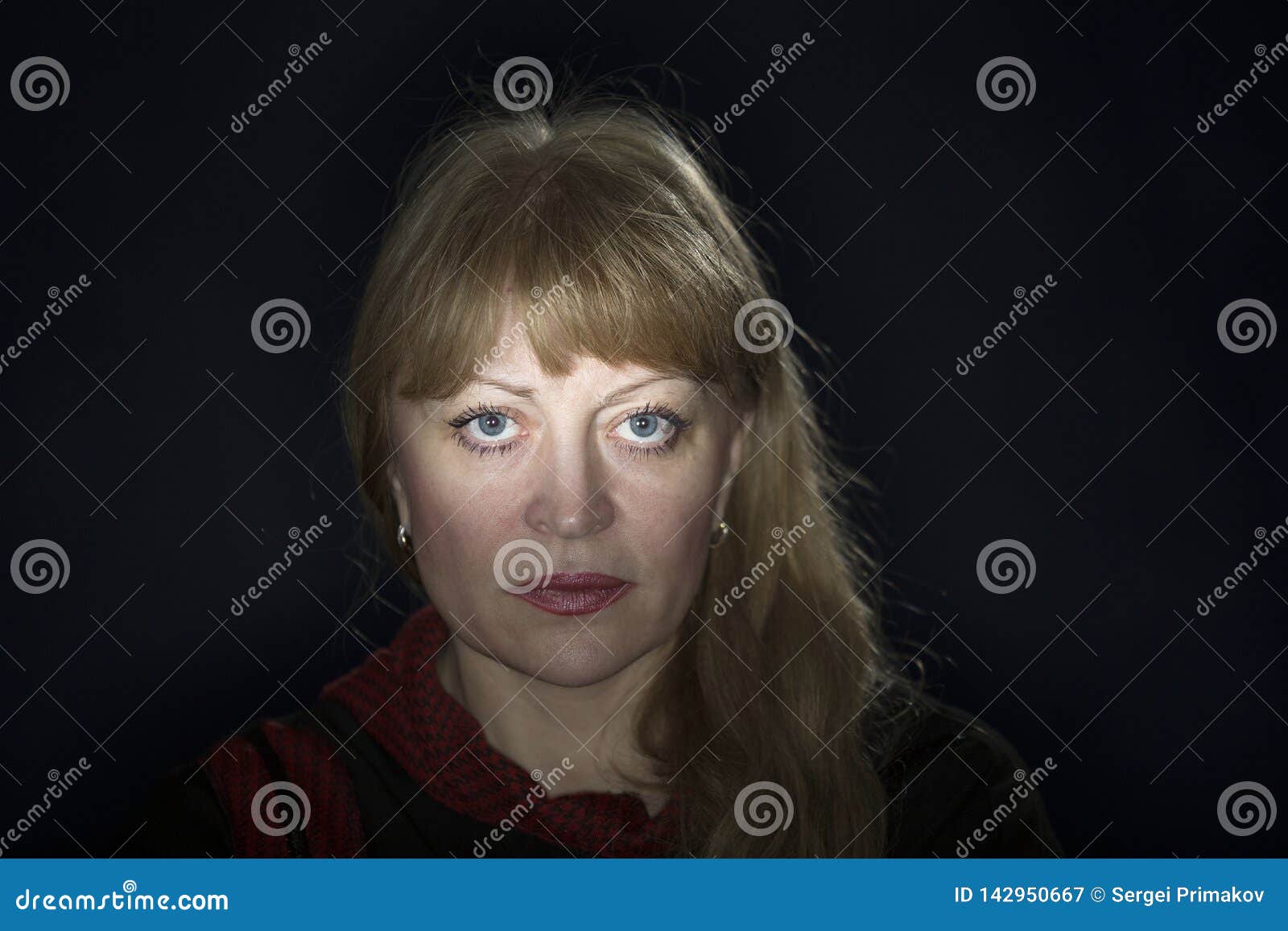 Portrait Of A 50 Years Old Blonde Against A Dark Background Stock