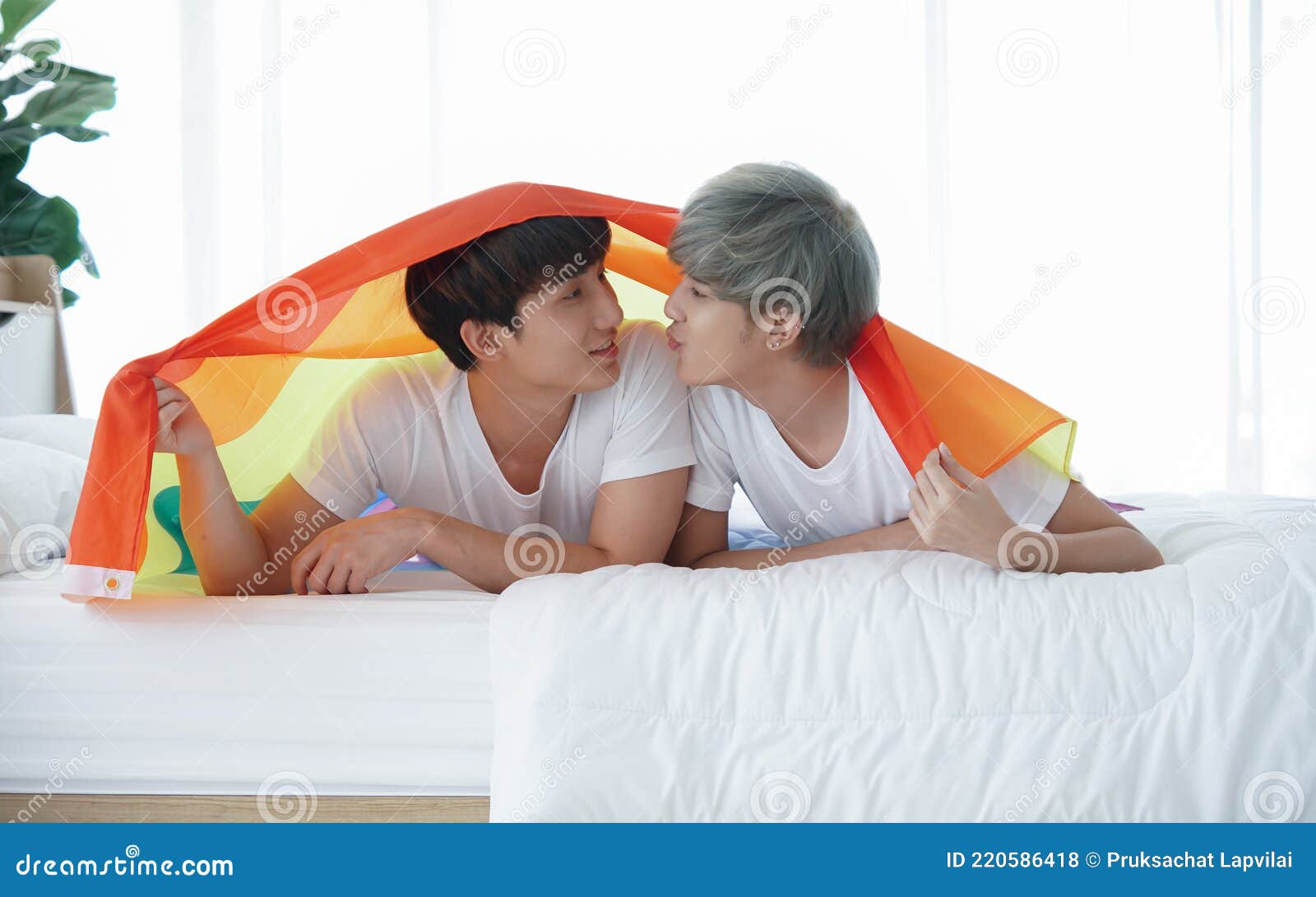 Portrait Of Young Asian Gay Couple Lying On Bed With Rainbow Flag Symbolic Of Lgbt Two Cute Men 