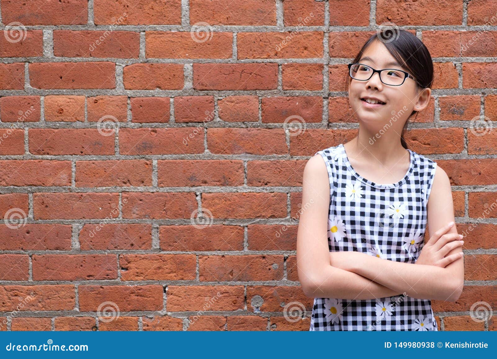 Portrait Of Young Asian Girl Against White Brick Wall 