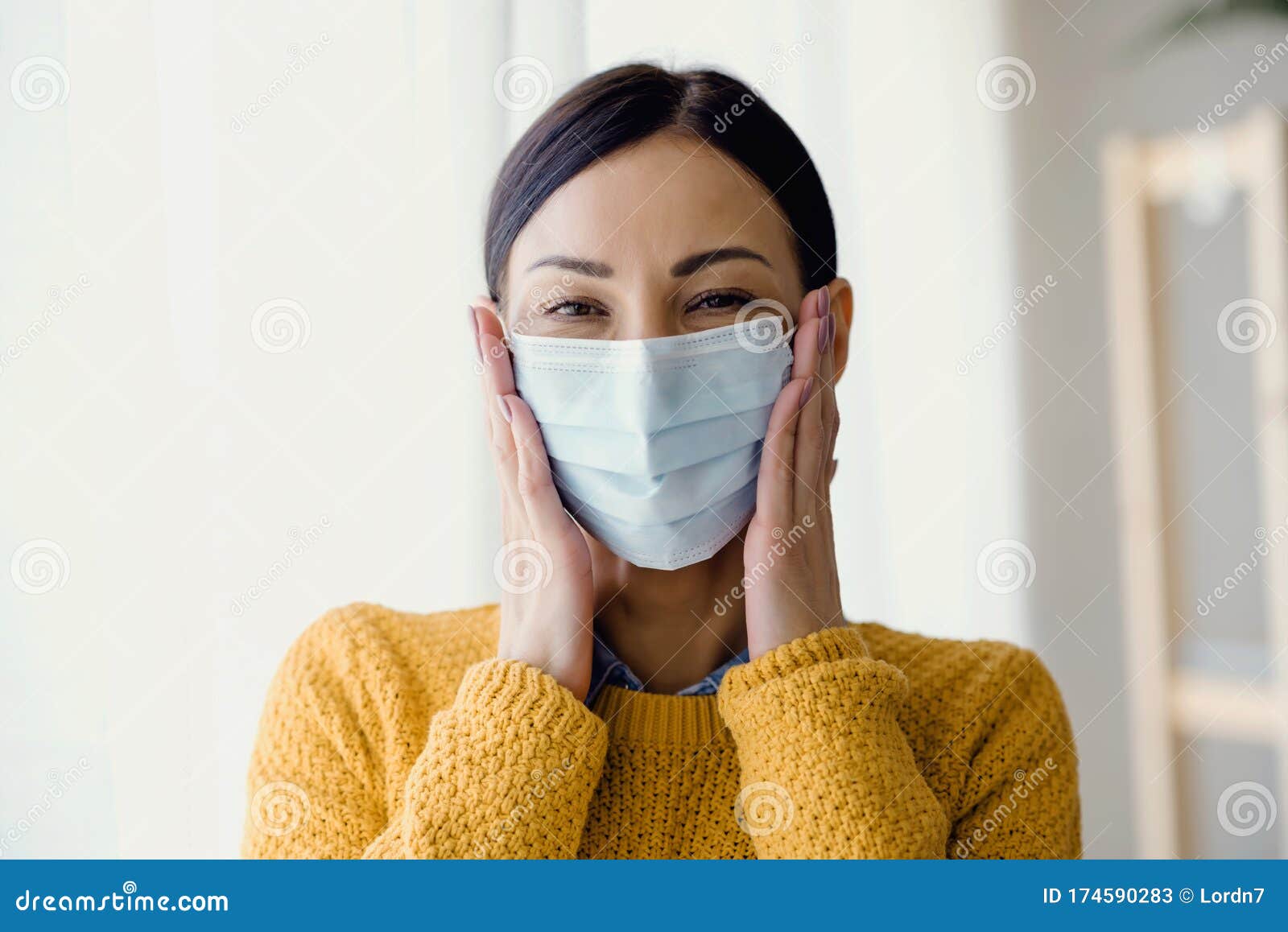 portrait of young asian woman,  putting on a medical surgical disposabhttpsle face mask to prevent infection