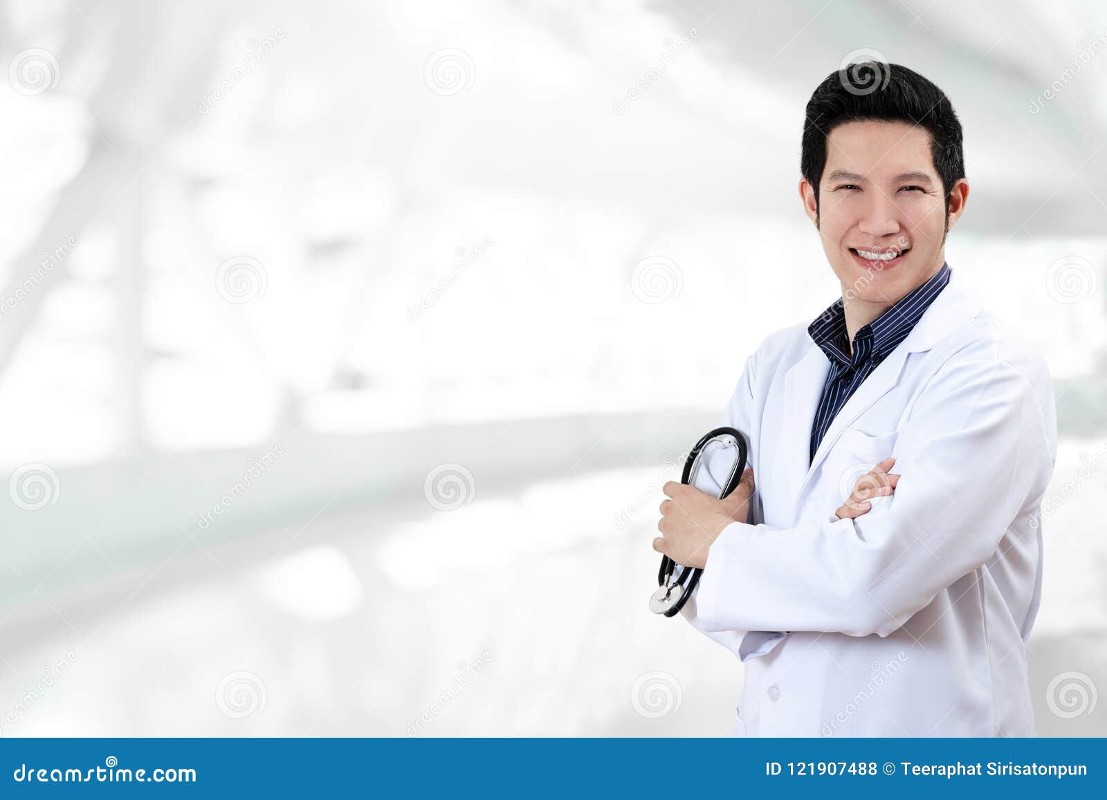 portrait of young attractive asian doctor or physician man crossed arms holding stethoscope medical equipment