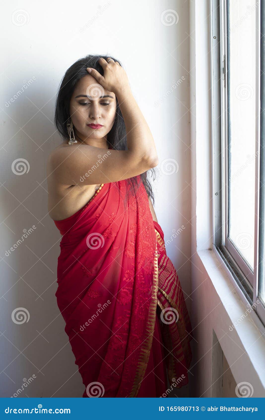 Portrait Of A Young Indian Woman Wearing A Red Saree Clothes And