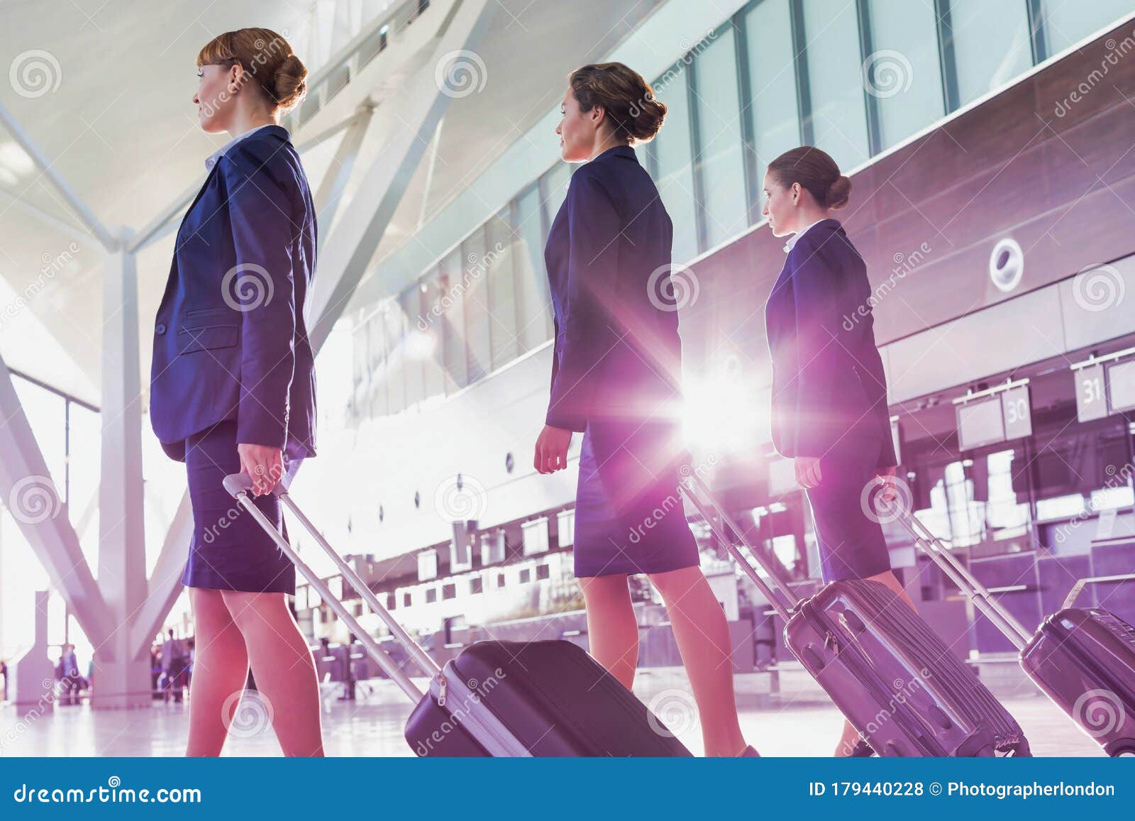 portrait of young beautiful confident flight attendants walking in airport