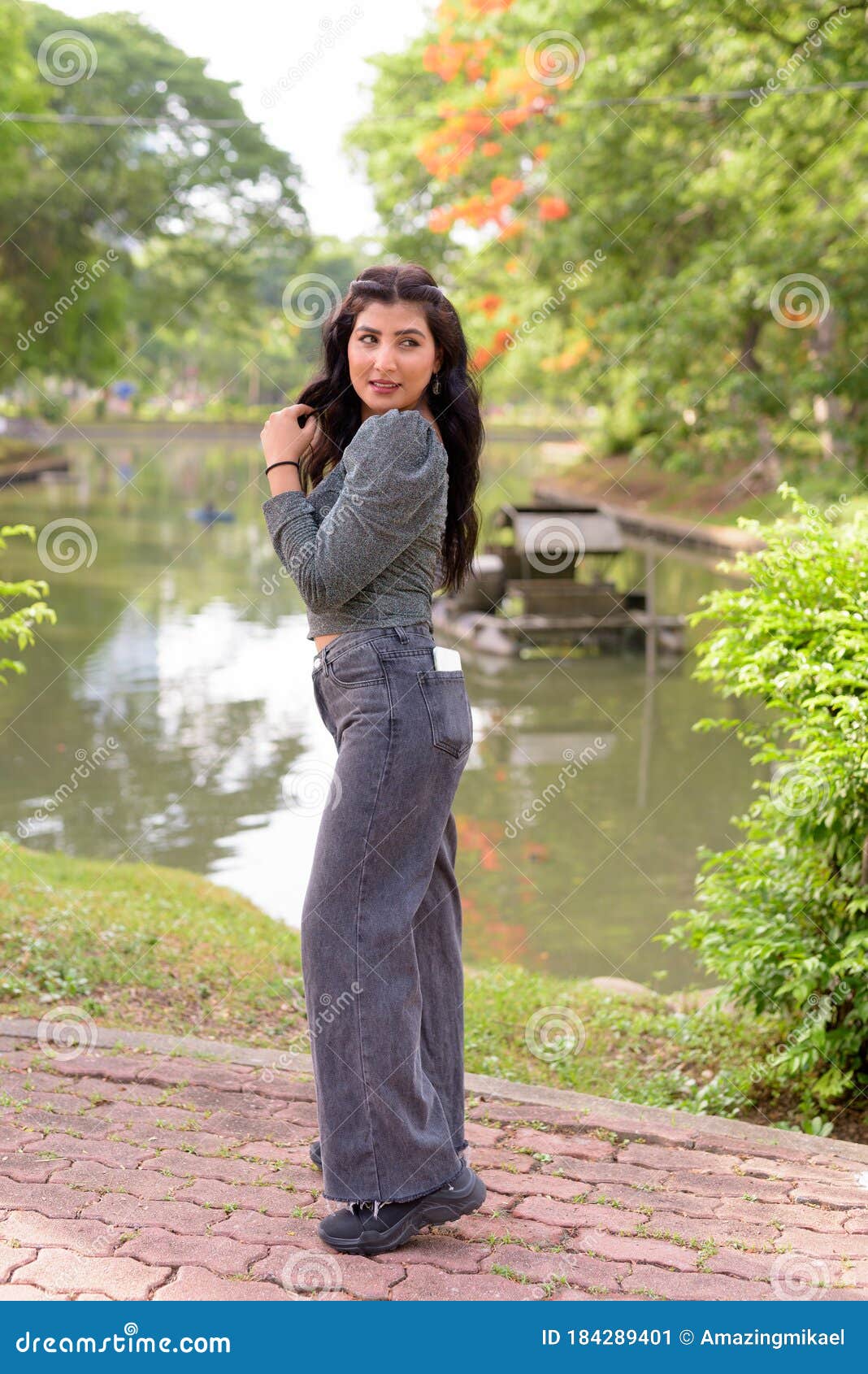 Full Body Shot Of Happy Young Beautiful Indian Woman Looking Back At