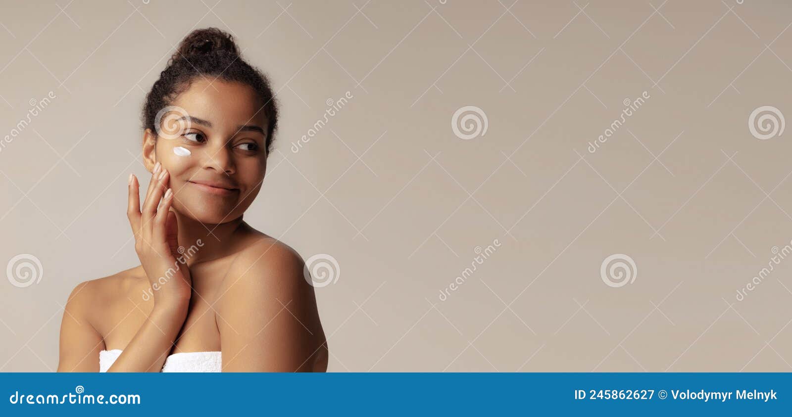 Portrait Of Young Beautiful Woman Applying Moisturizing Cream Taking Care After Skin Over Grey