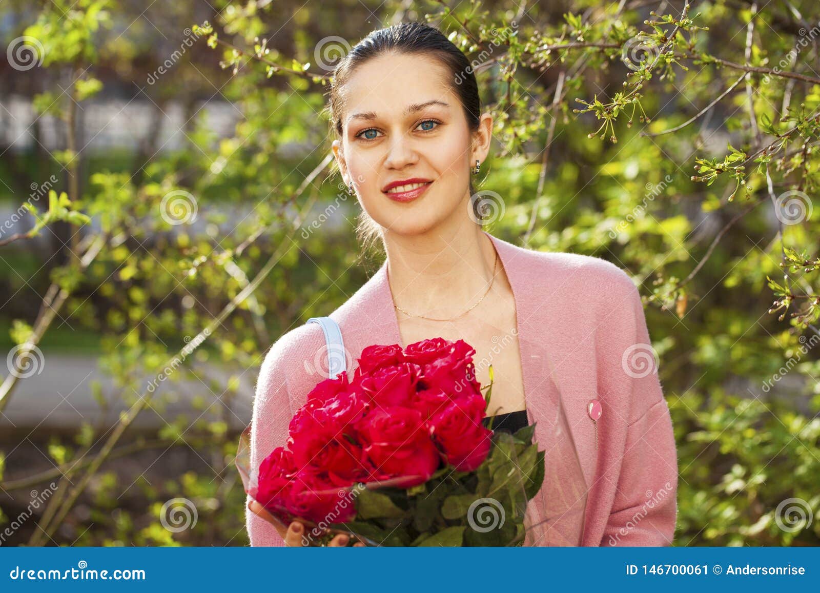 Portrait of a Young Beautiful Woman with a Bouquet of Red Roses in ...