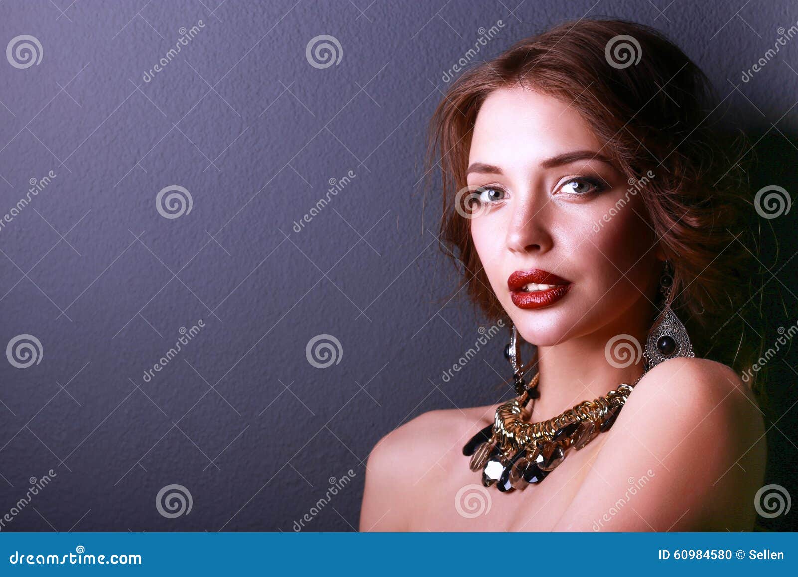 Portrait of young beautiful woman with jewelry .