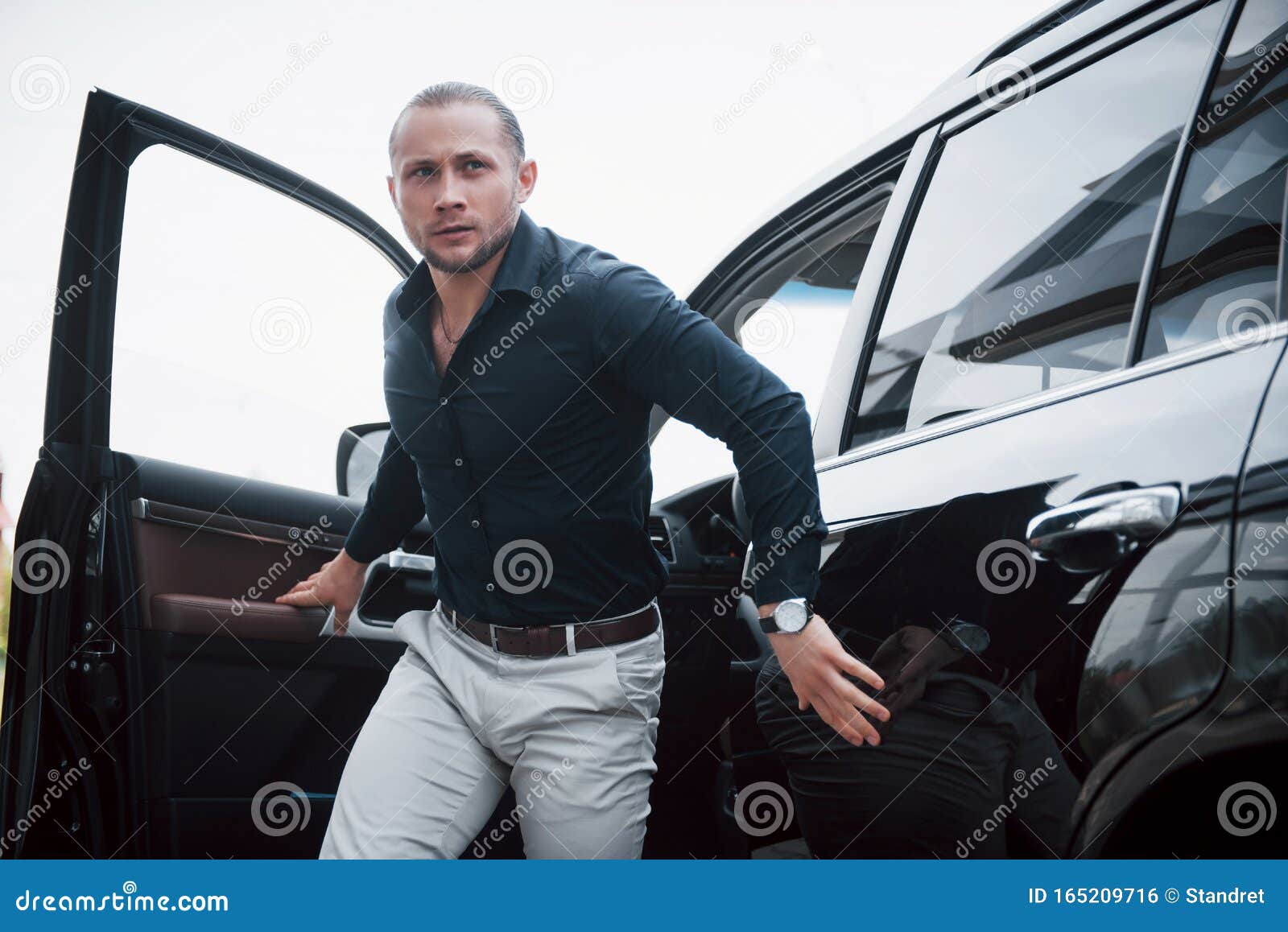 Portrait of a Young Bodyguard Near the Car. he Performs Dangerous Work