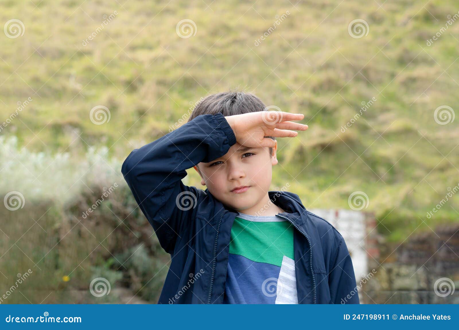 Portrait of Young Boy with Hand Up Shielding Bright Sunlight Shining in ...