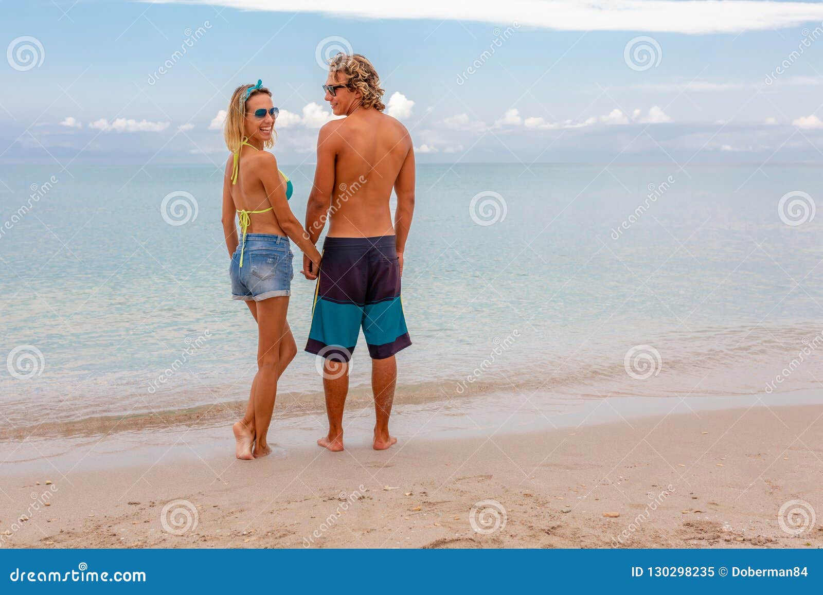 Portrait of Young Couple in Love Embracing at Beach and Enjoying Time