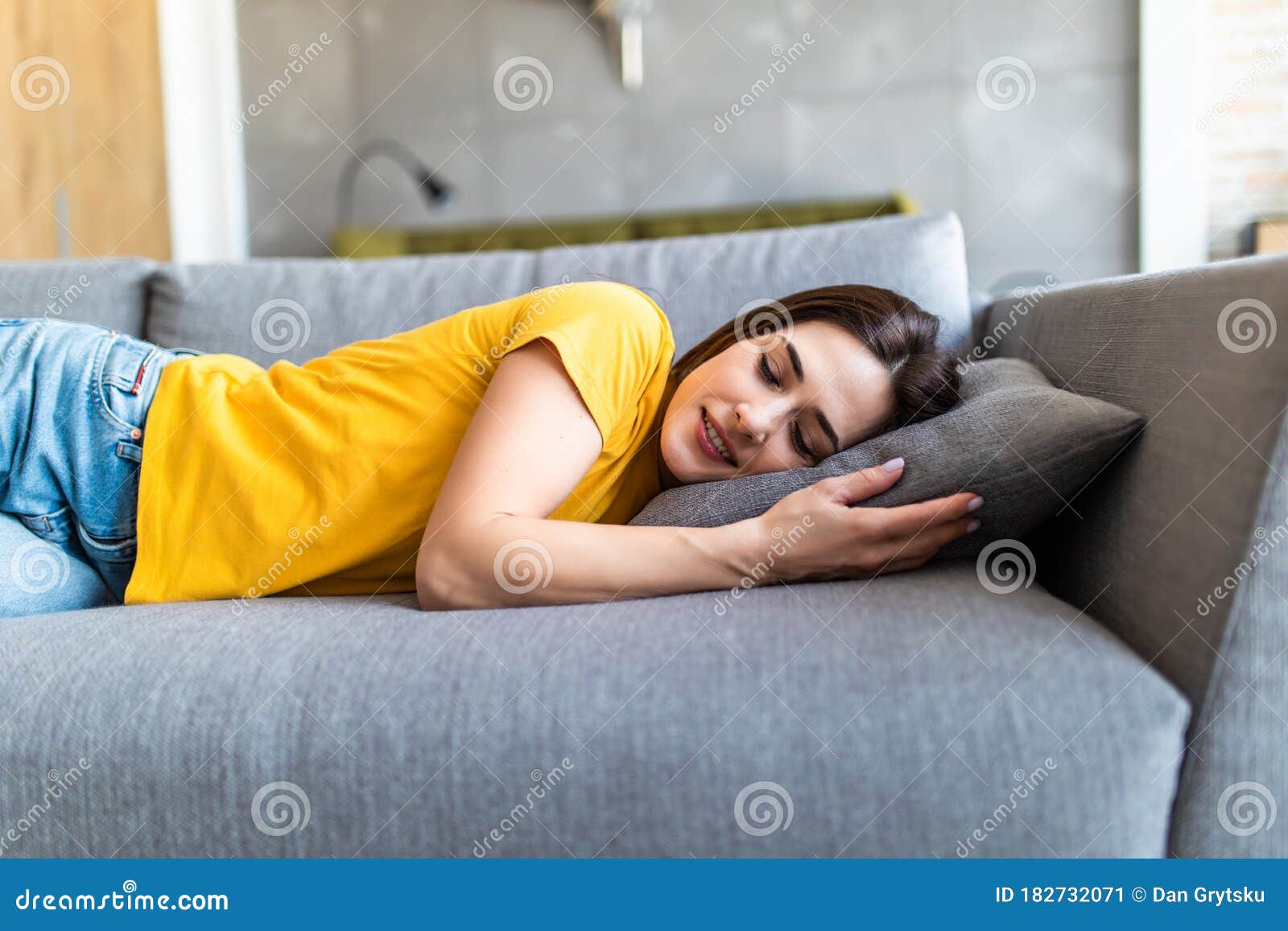 Portrait Of A Young Cute Brunette Girl Sleeping On The Sofa In Light