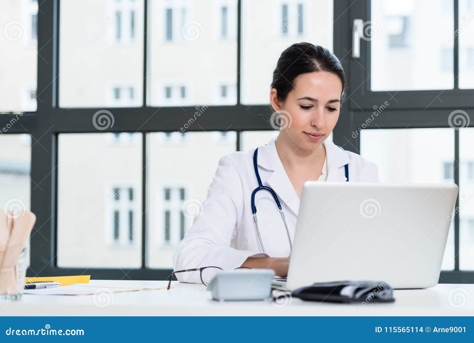 portrait of young female physician working on laptop in the office
