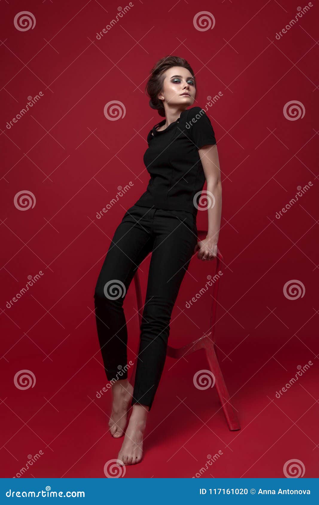 full length portrait of black haired girl wearing leather outfit. sitting  pose, isolated on a white studio background. Stock Photo | Adobe Stock