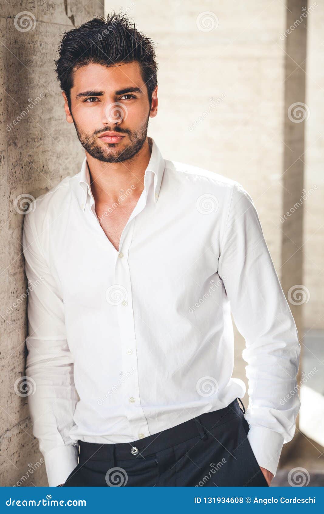 portrait of young handsome man in white shirt outdoor.