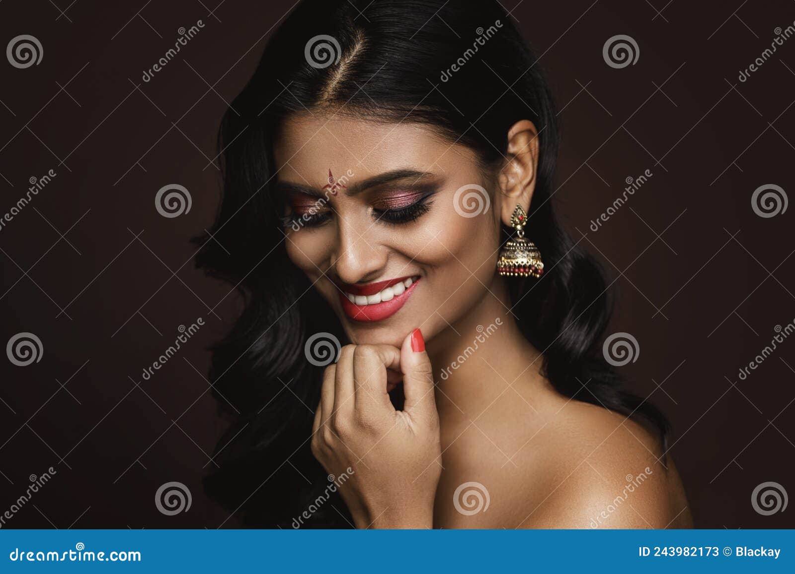 Portrait of Indian woman with beautiful makeup and hairstyle on brown  background 16235620 Stock Photo at Vecteezy