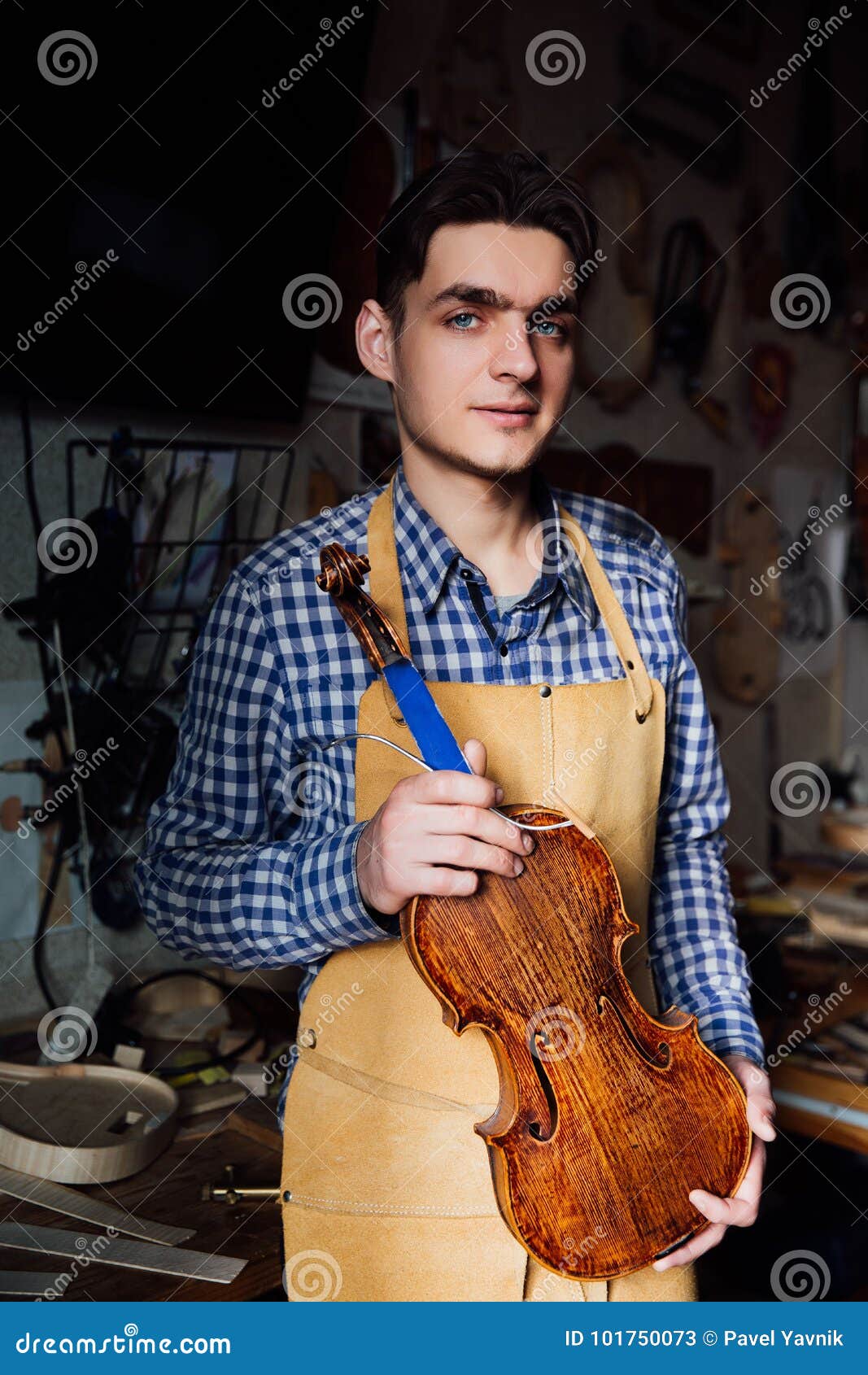 Portrait of a Young Luthier with a Handcrafted Violin in His