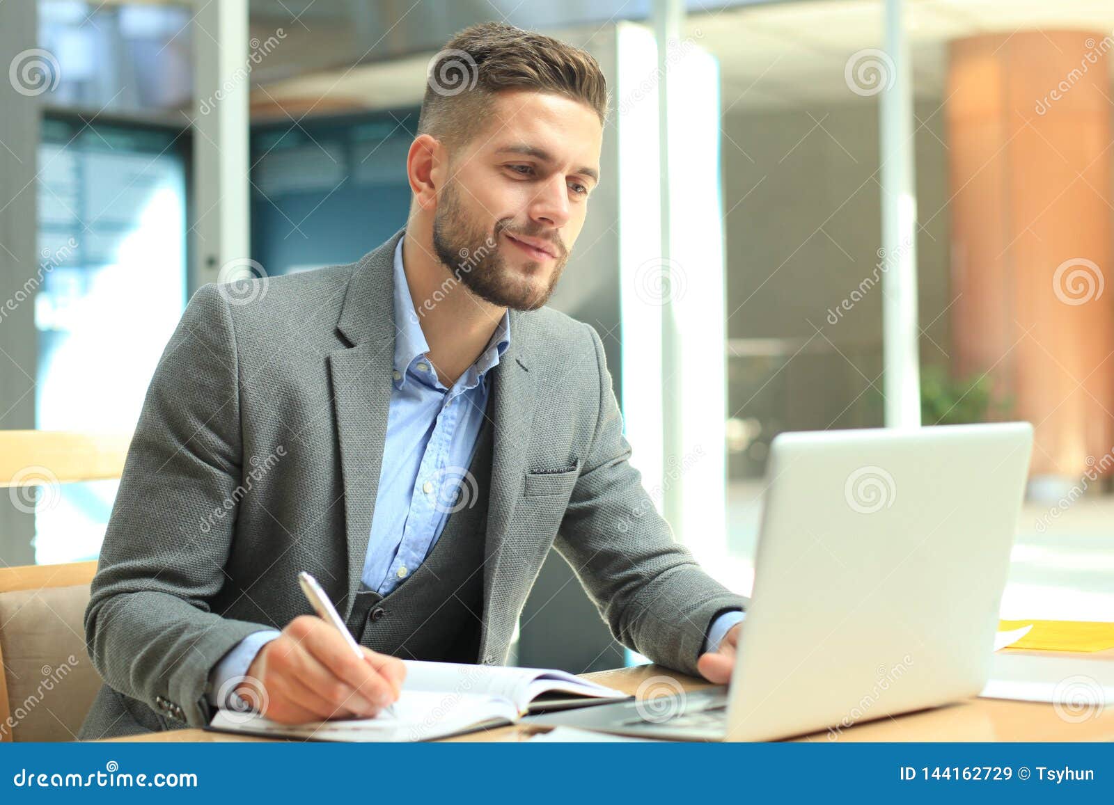 Portrait of Young Man Sitting at His Desk in the Office. Stock Image
