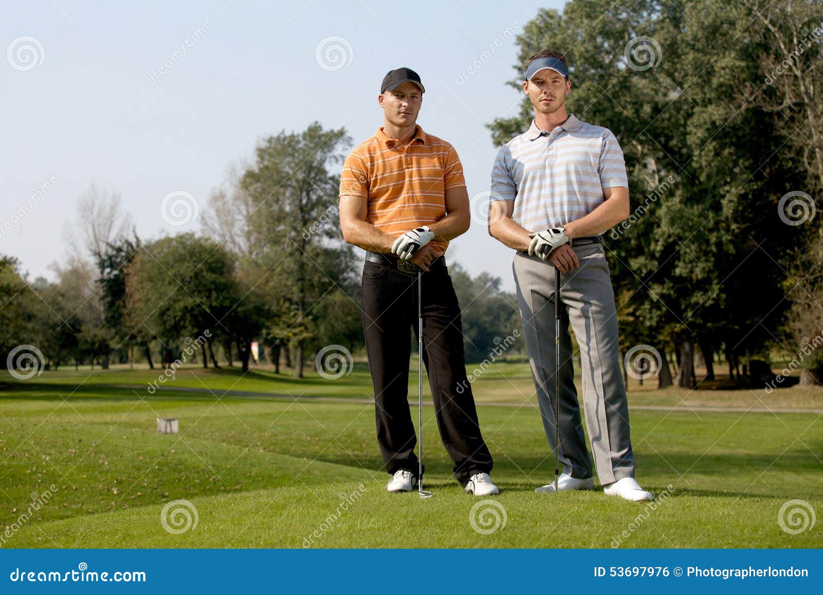 Portrait of Young Men Standing with Golf Sticks on Golf Course Stock