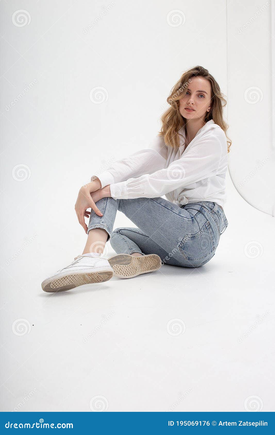 Caucasian Woman Posing in Shirt and Blue Jeans, Sitting on White Studio ...