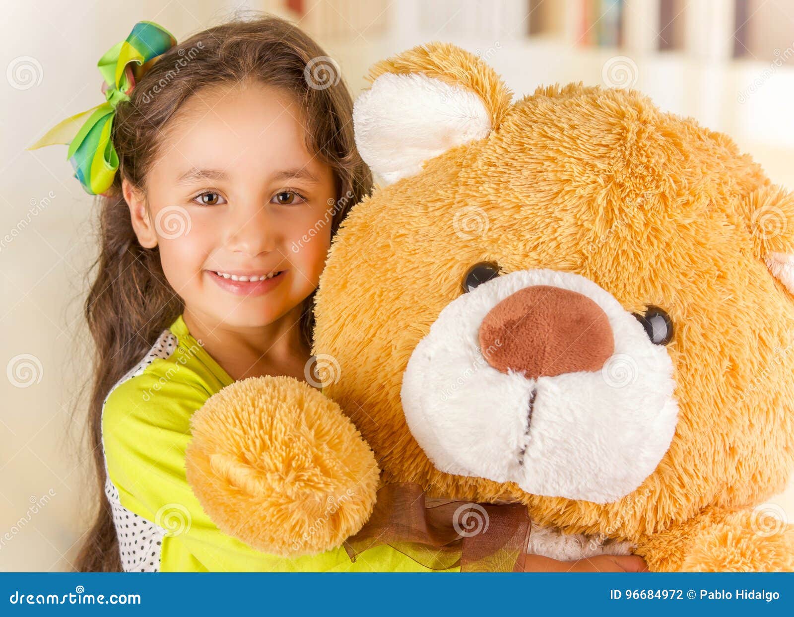 A Portrait of a Young Pretty Girl Smiling and Hugging Her Teddy Bear ...