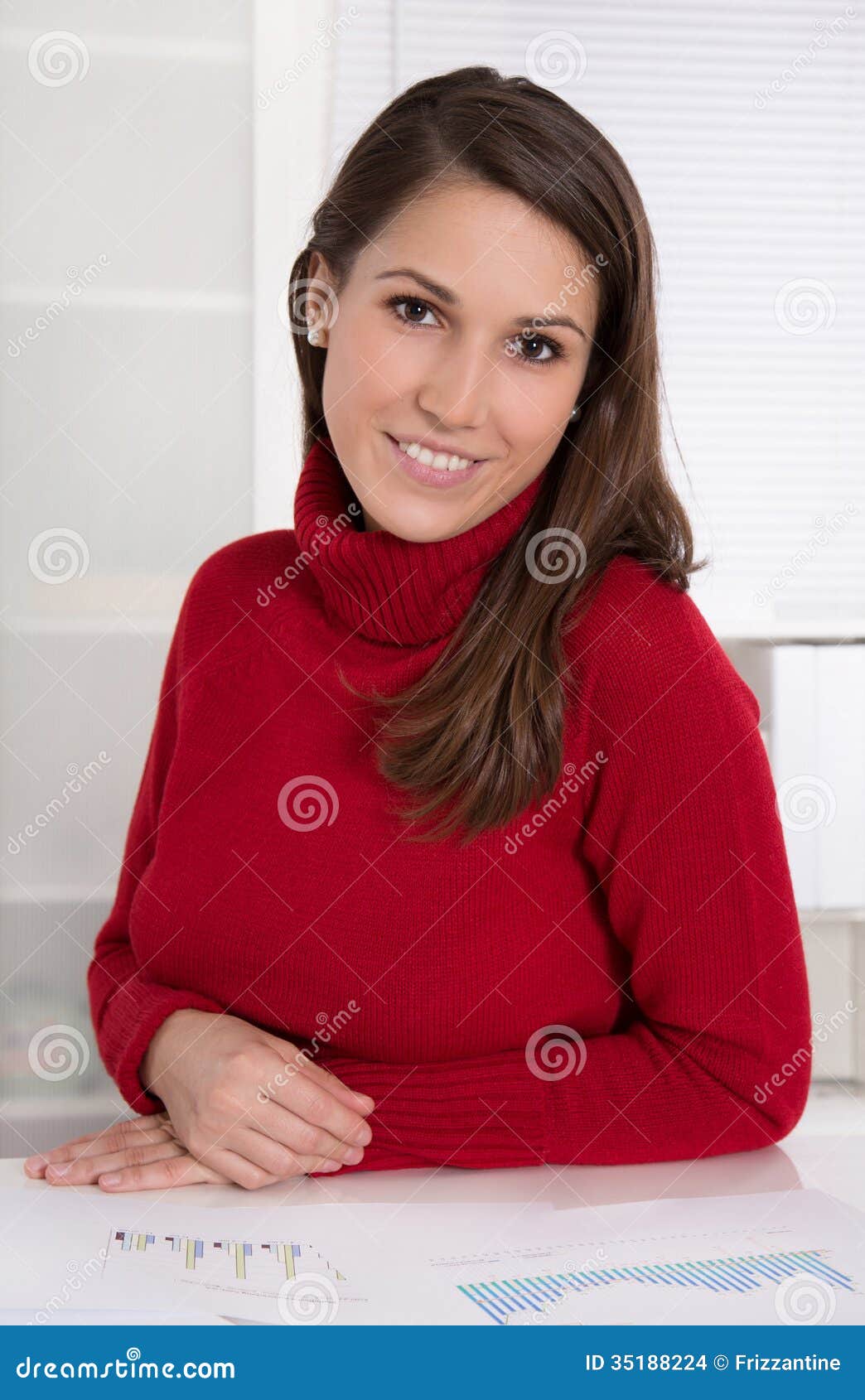 portrait of a young pretty woman at desk - trainee in an office