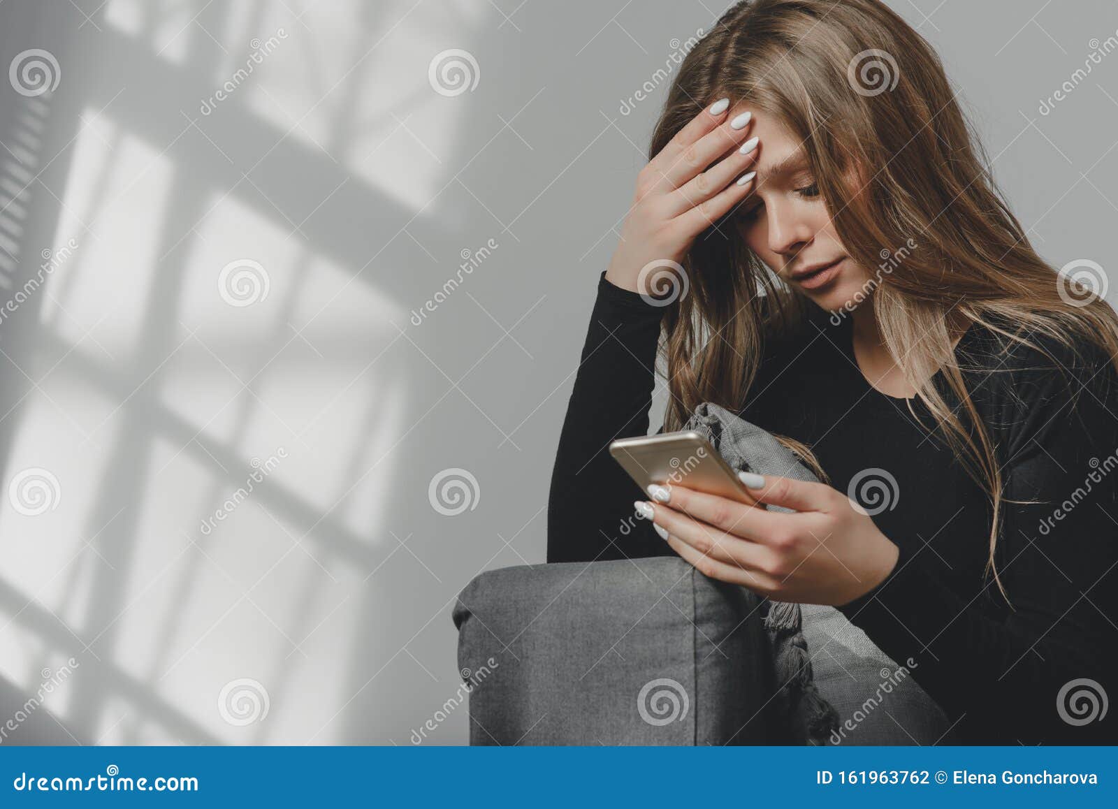 Portrait of a Young Sad Crying Girl with a Smartphone in Her Hand ...