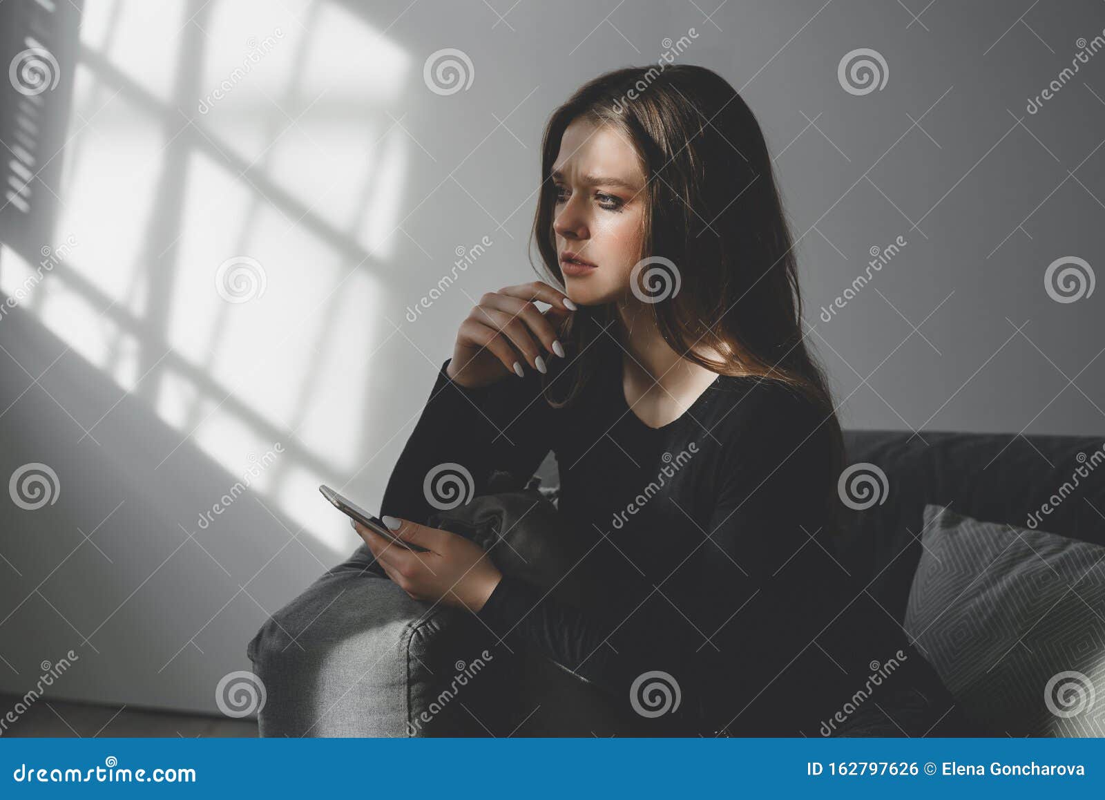 Portrait of a Young Sad Crying Girl with a Smartphone in Her Hand ...