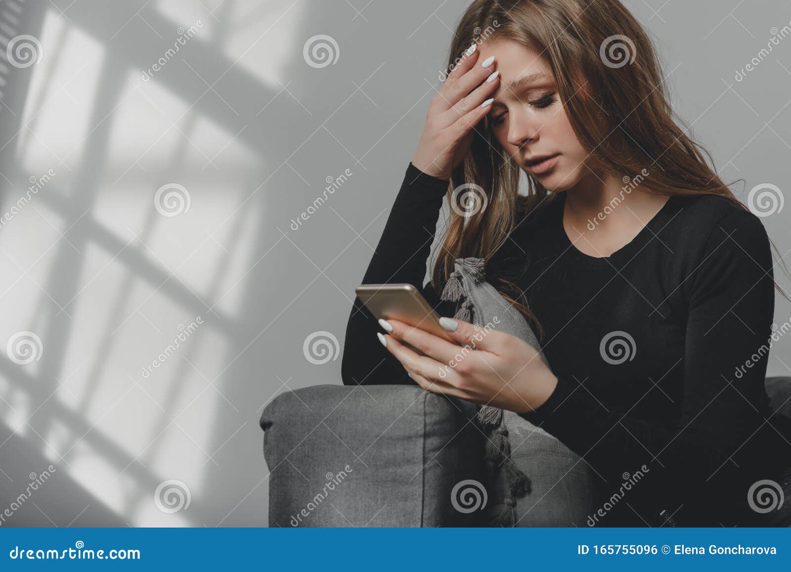 Portrait of a Young Sad Crying Girl with a Smartphone in Her Hand ...