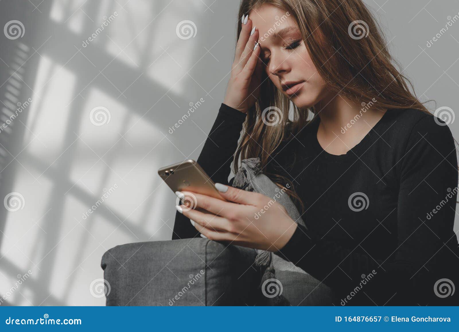 Portrait of a Young Sad Crying Girl with a Smartphone in Her Hand ...