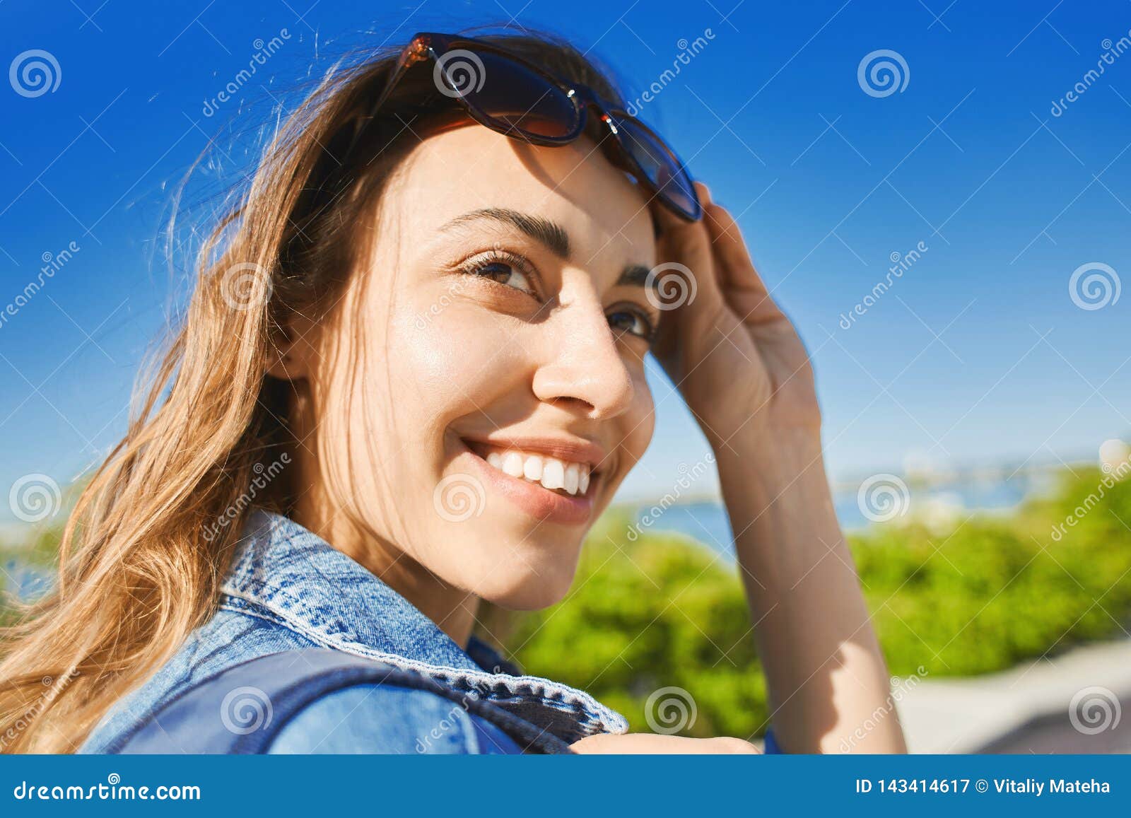 Portrait Of A Young Smiling Attractive Woman With Sunglasses At Sunny Day On The Blue Sky 