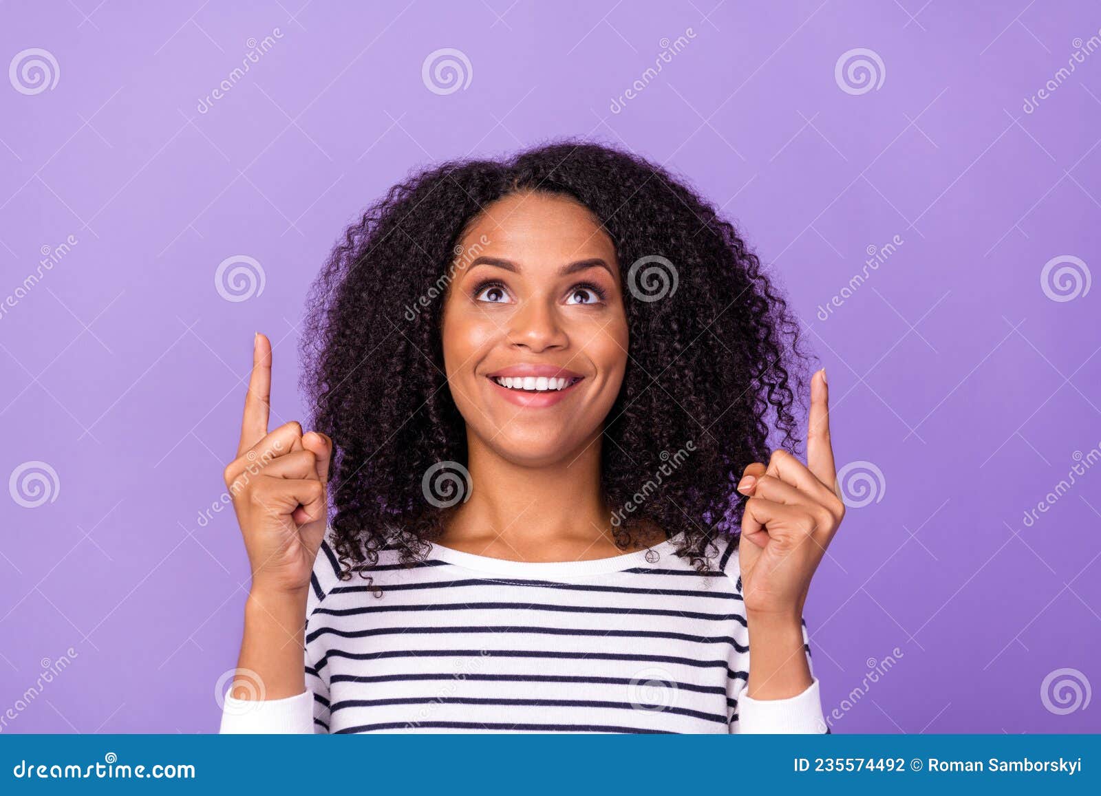 portrait of young smiling girl look up advertising product offer point fingers copyspace  on purple color