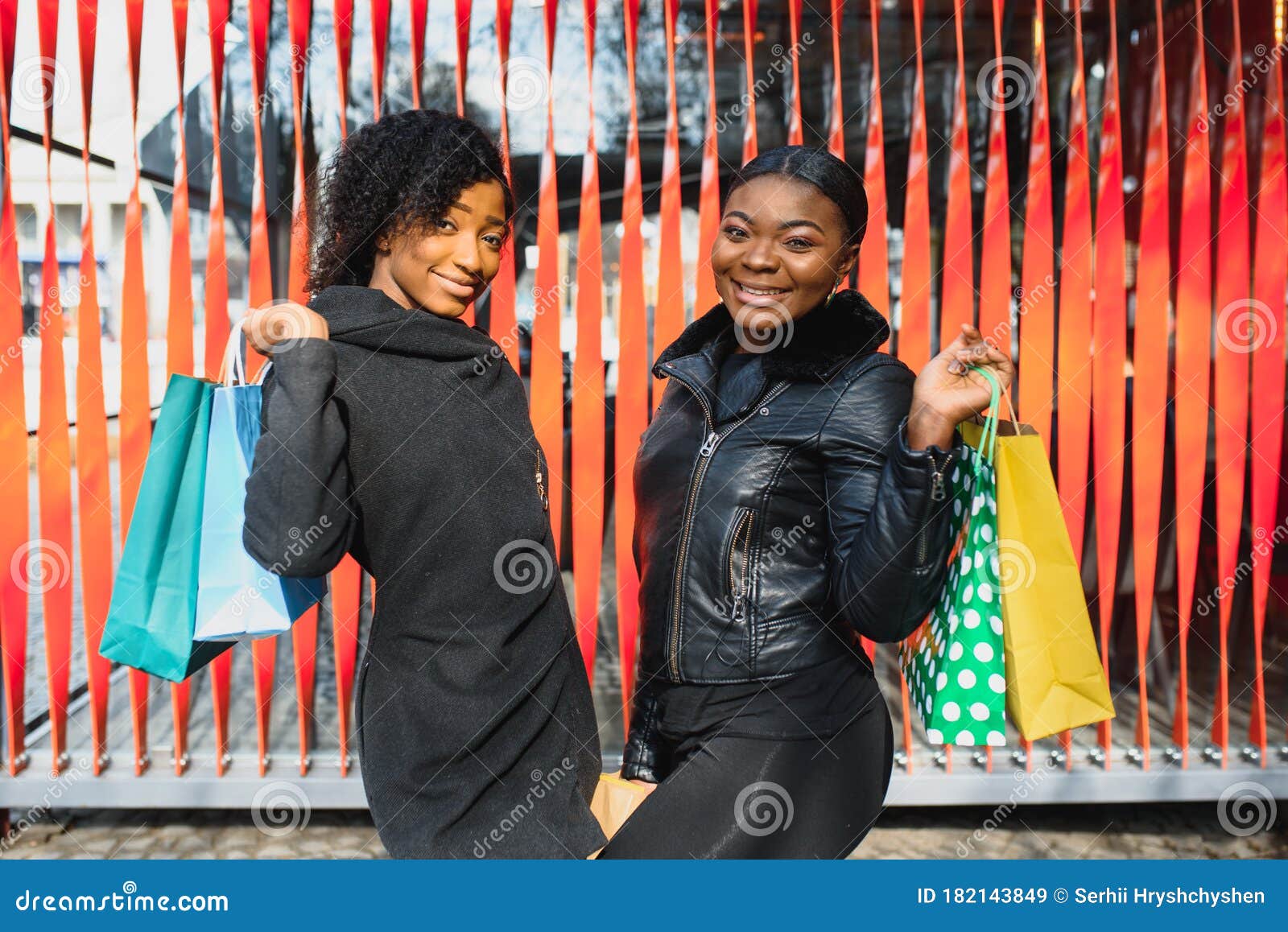 Portrait of Young Two African Ladies Friends Standing Over Red Wall and ...