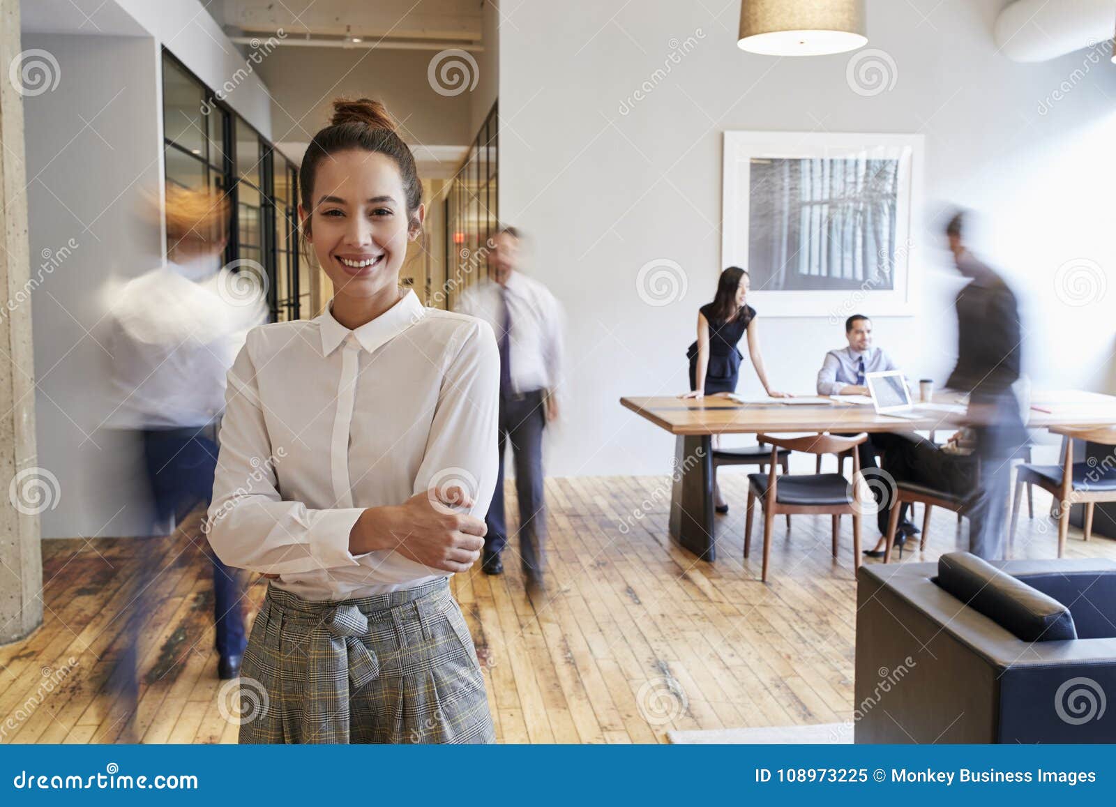 portrait of young white woman in a busy modern workplace