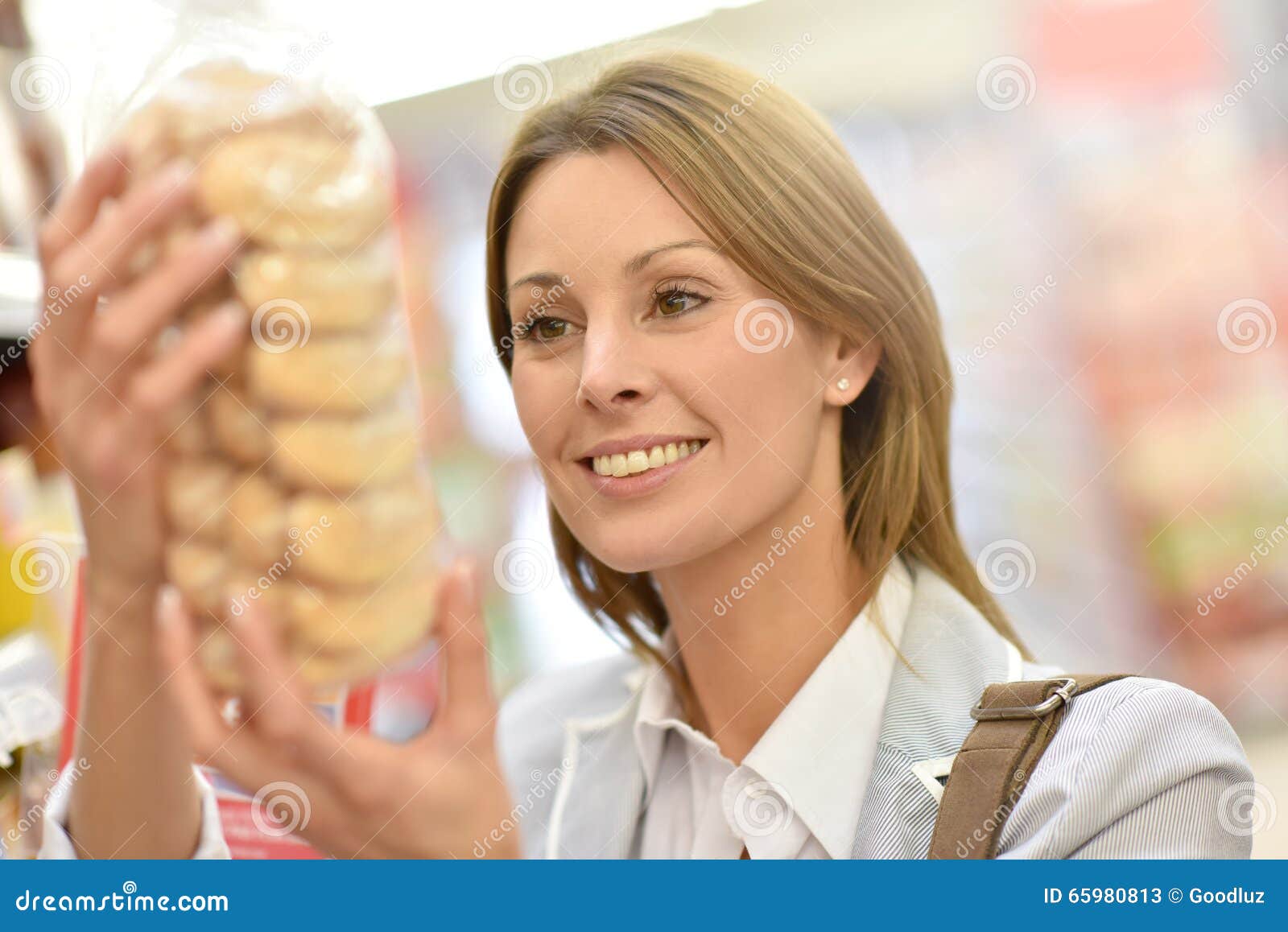 Portrait of young woman buying cookies. Portrait of beautiful woman holding cookies bag in supermarket