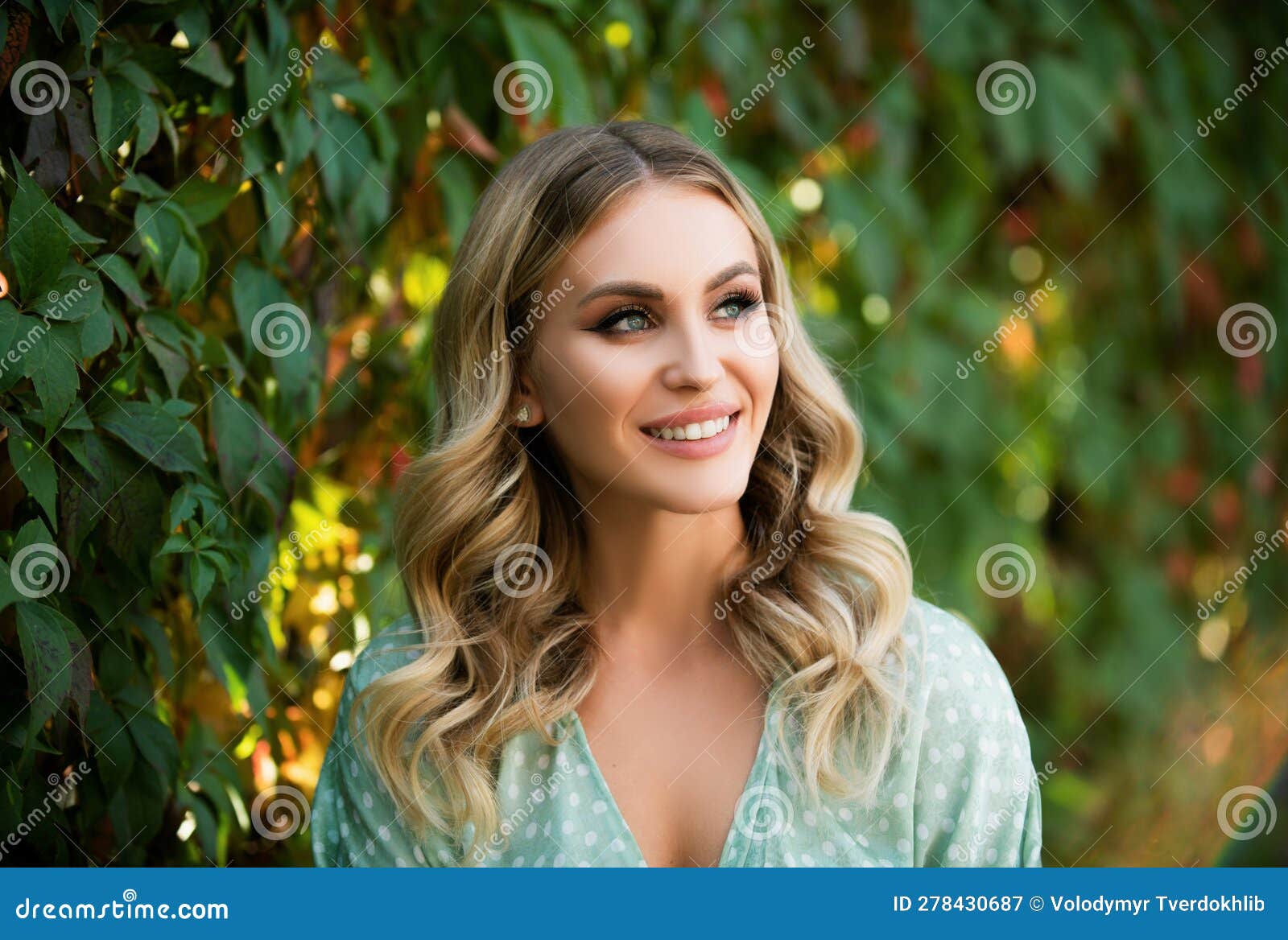 portrait of young woman looking eways in summer park outdoor. romantic girl with beauty face. woman with romantic smile