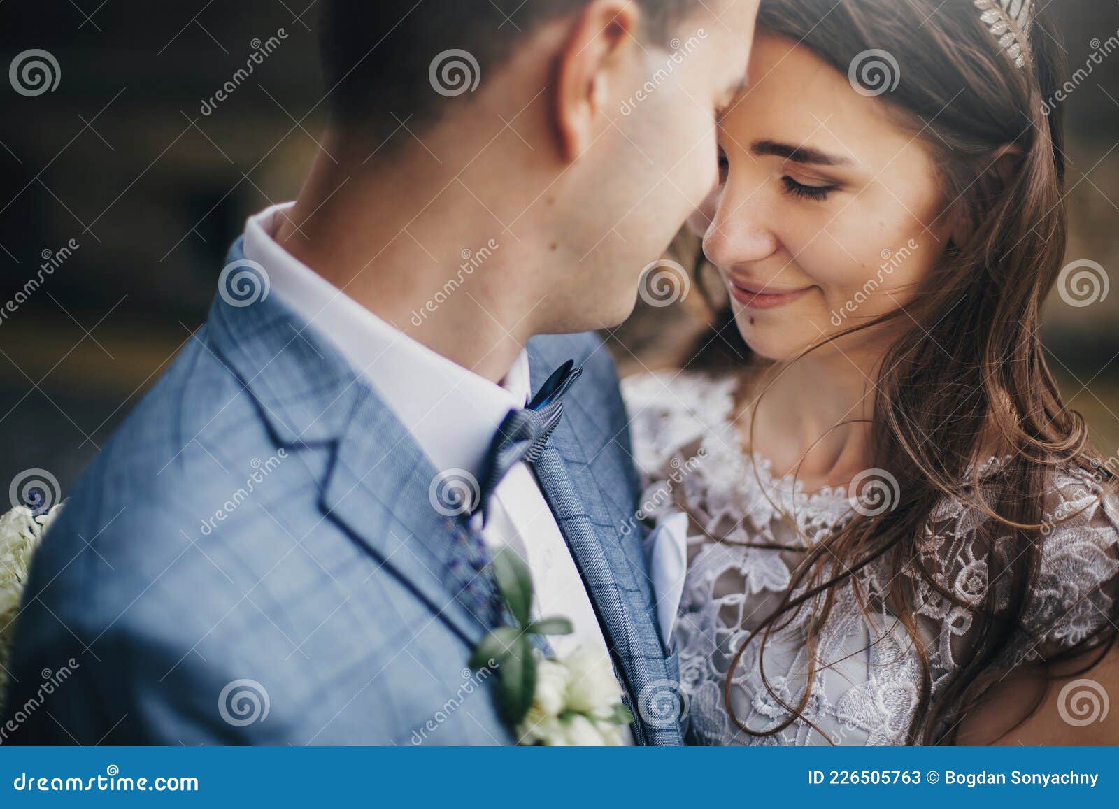 Portraits of Stylish Bride and Groom Embracing on Background of Old