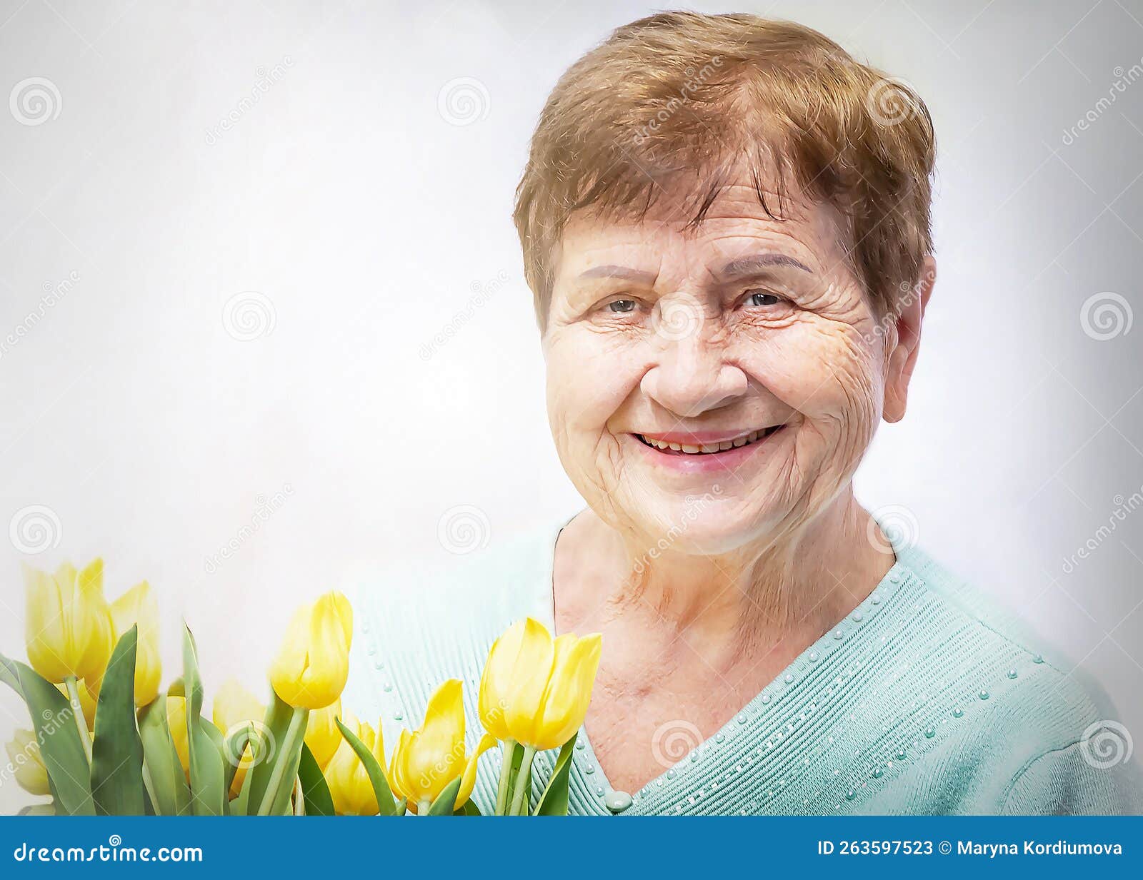 portret of smiling, positive senior elderly woman with bunch of yellow flowers tulipan. happy, healthy grandmother.